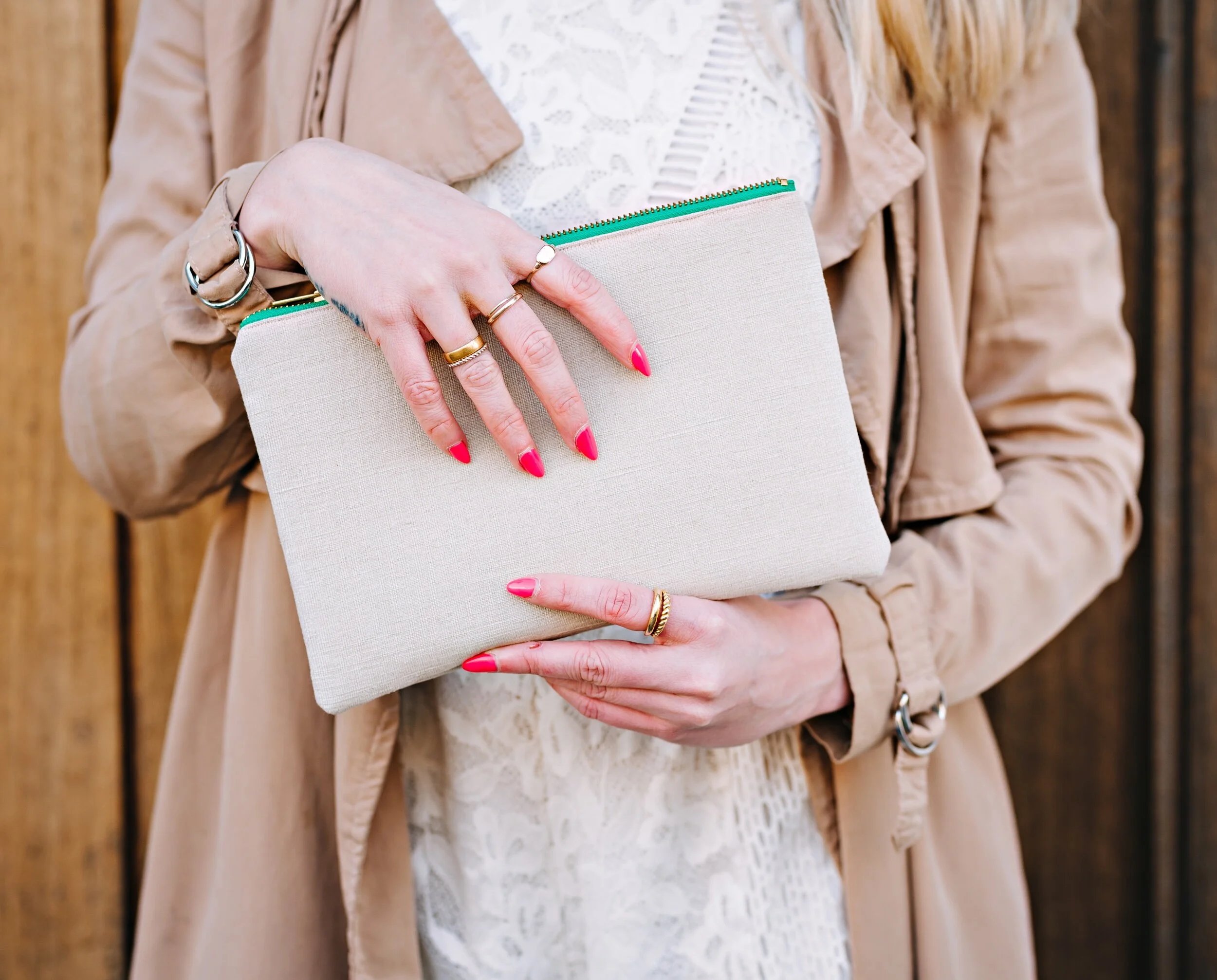 Woman wearing white lace playsuit beige mac holding hemp clutch bag green aqua zip