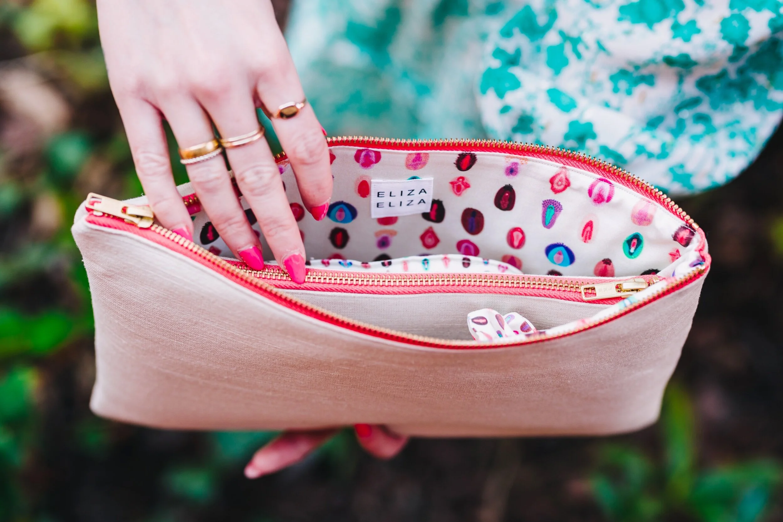Opened V Collection Large Clutch Bag with hand reaching in for purse