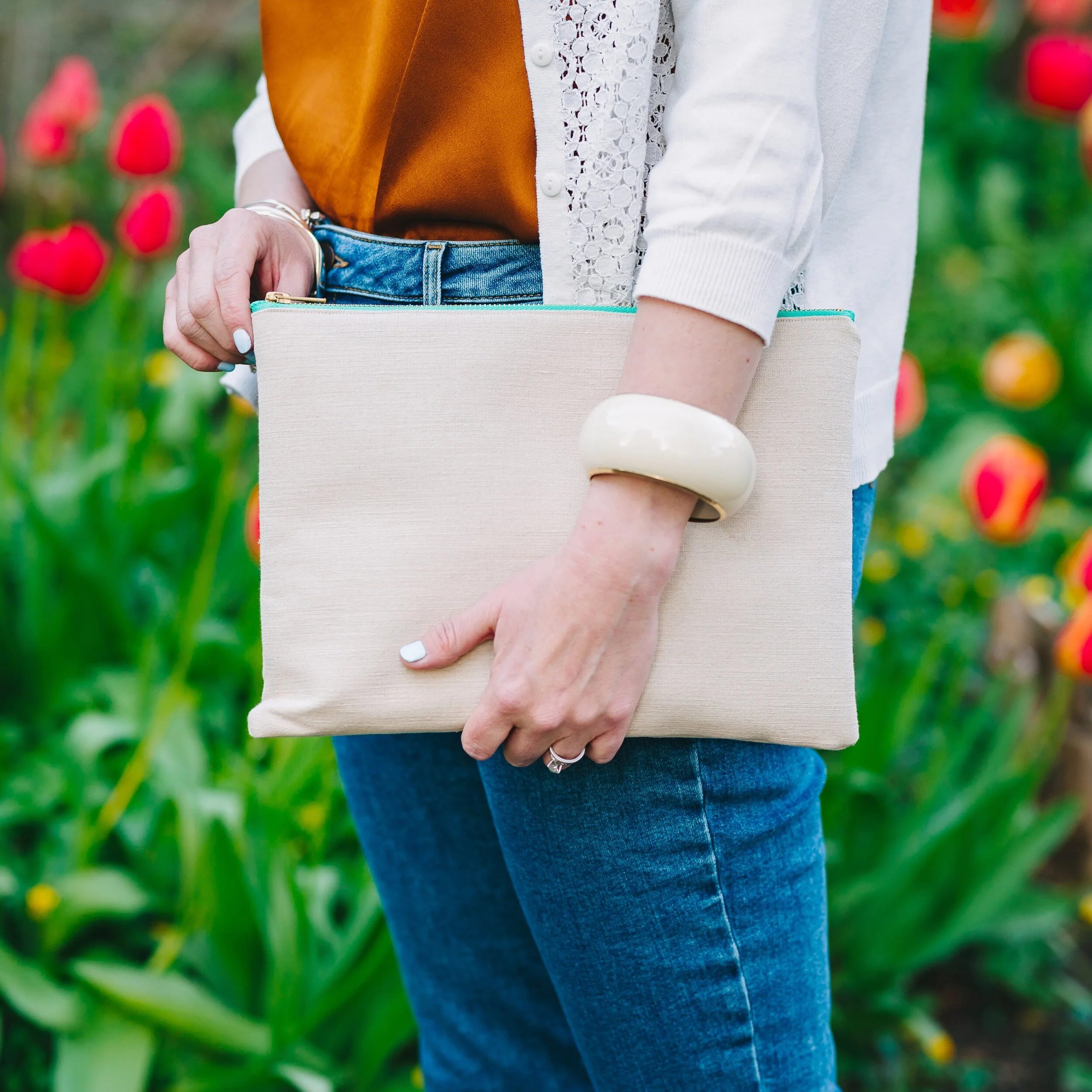 Woman holding turtle collection large clutch bag green aqua zip