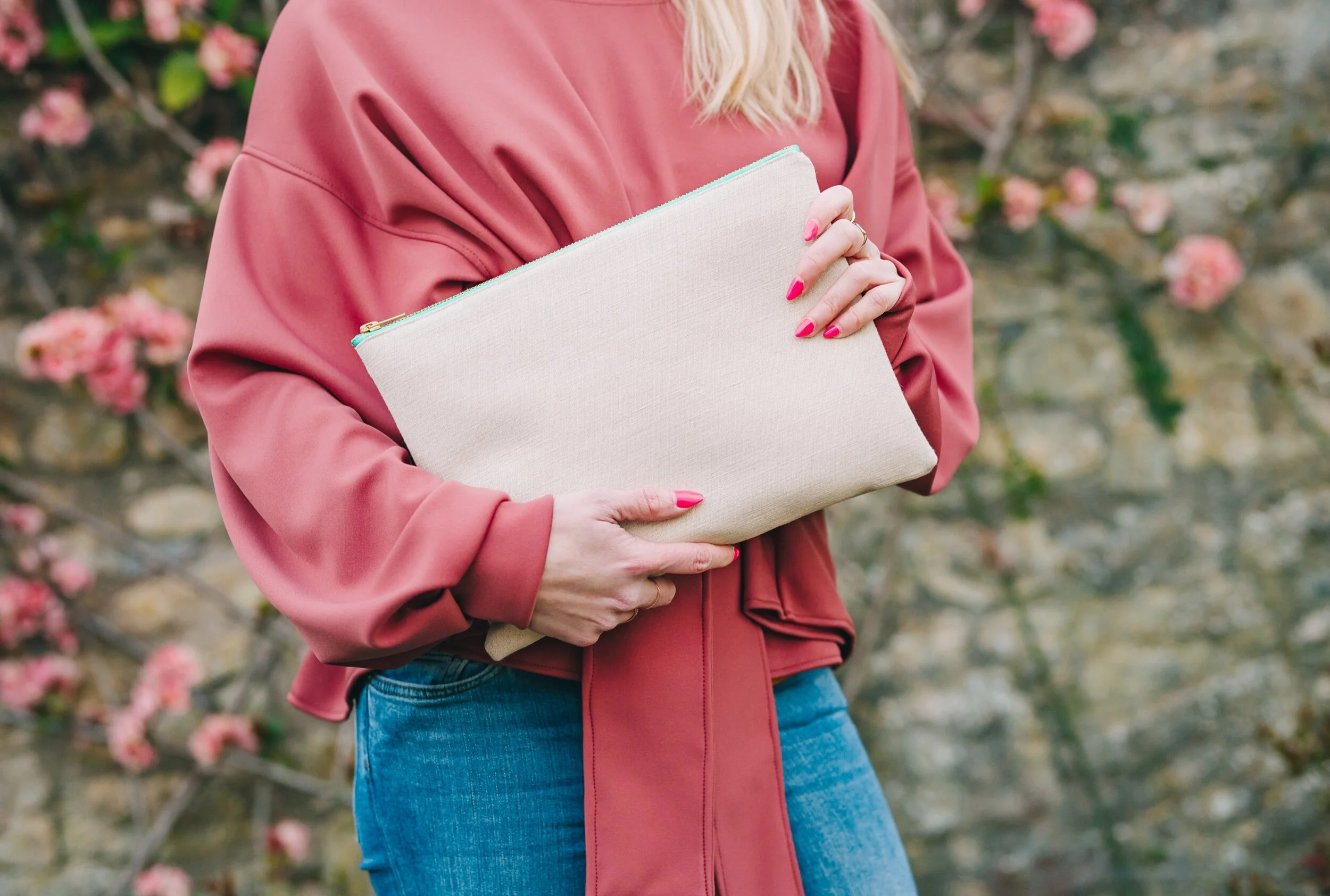 Woman wearing dark pink wrap jersey top holds turtle collection large clutch bag aqua green zip