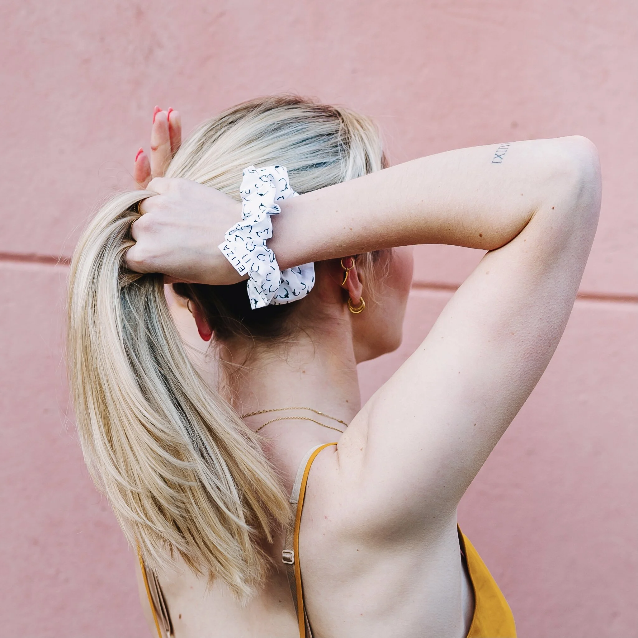 Woman putting up hair ponytail  with an organic cotton Eliza Eliza B Collection scrunchie