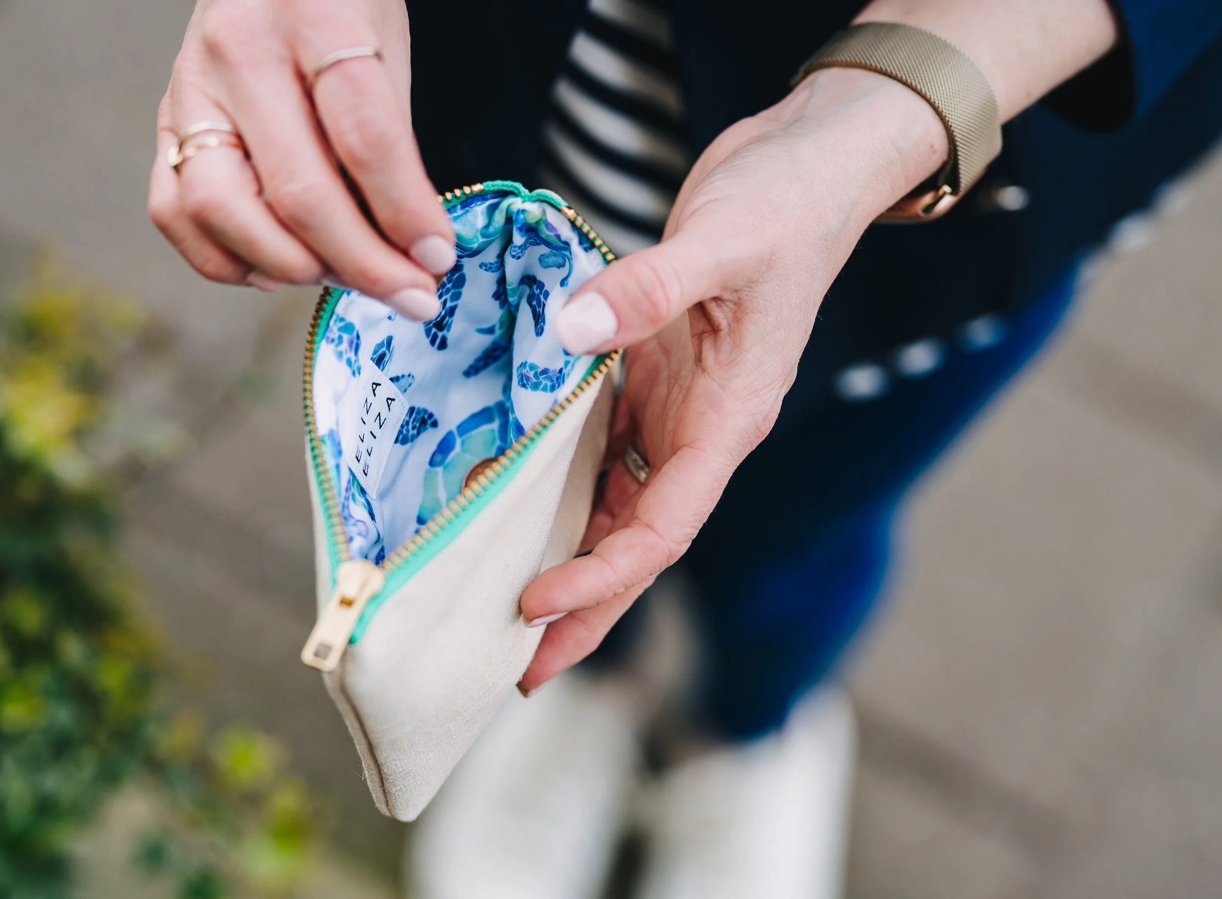 Woman holds open turtle hemp cotton purse to see lining