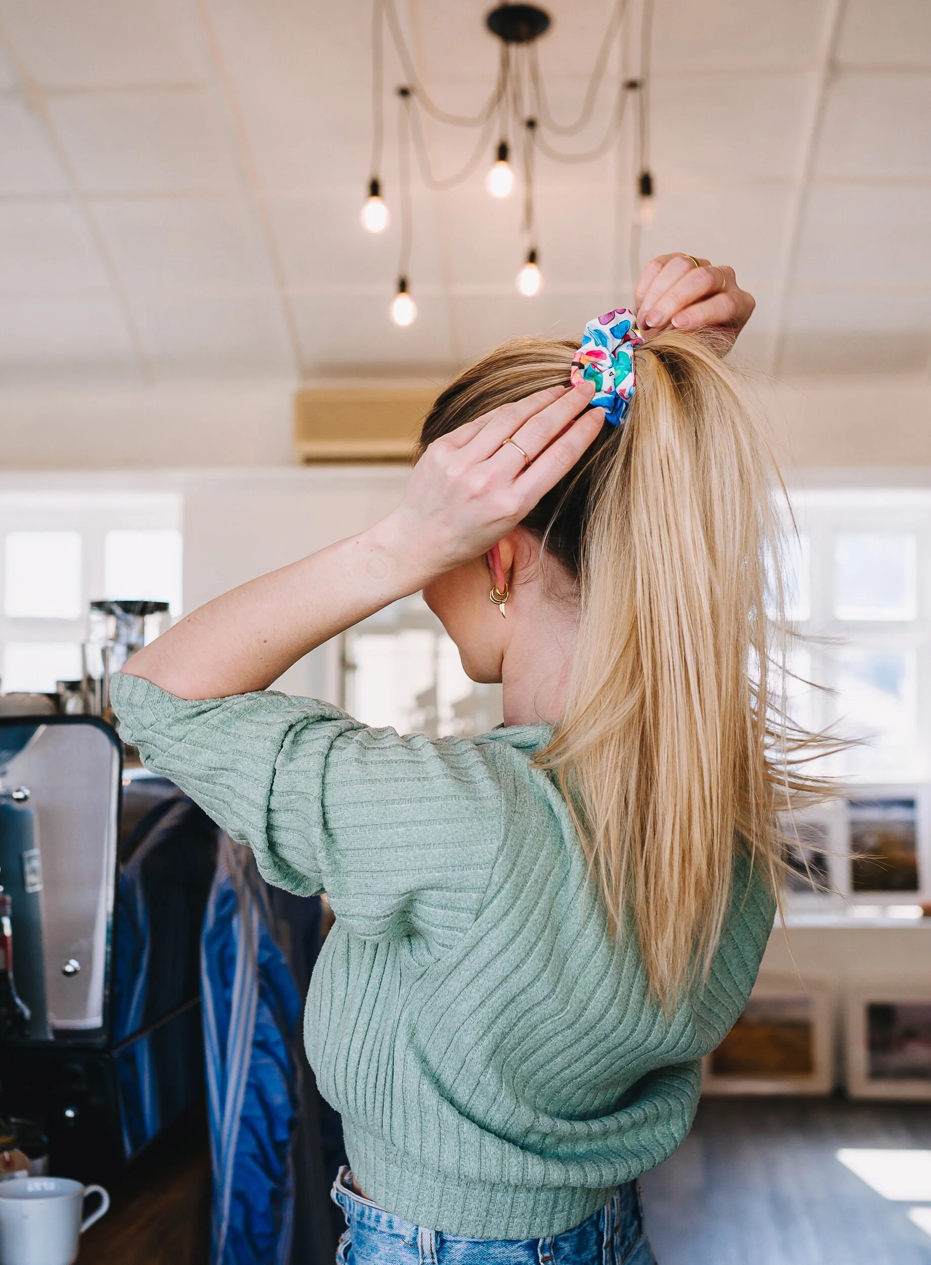Woman puts up hair ponytail with organic cotton scrunchie