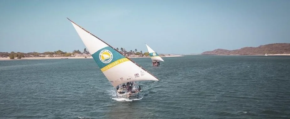 Flipflopi dhow under sail in Mkokoni, with a large sail saying we need to protect our ocean.