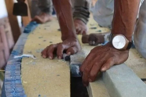 Hands on a colourful recycled plastic boat part