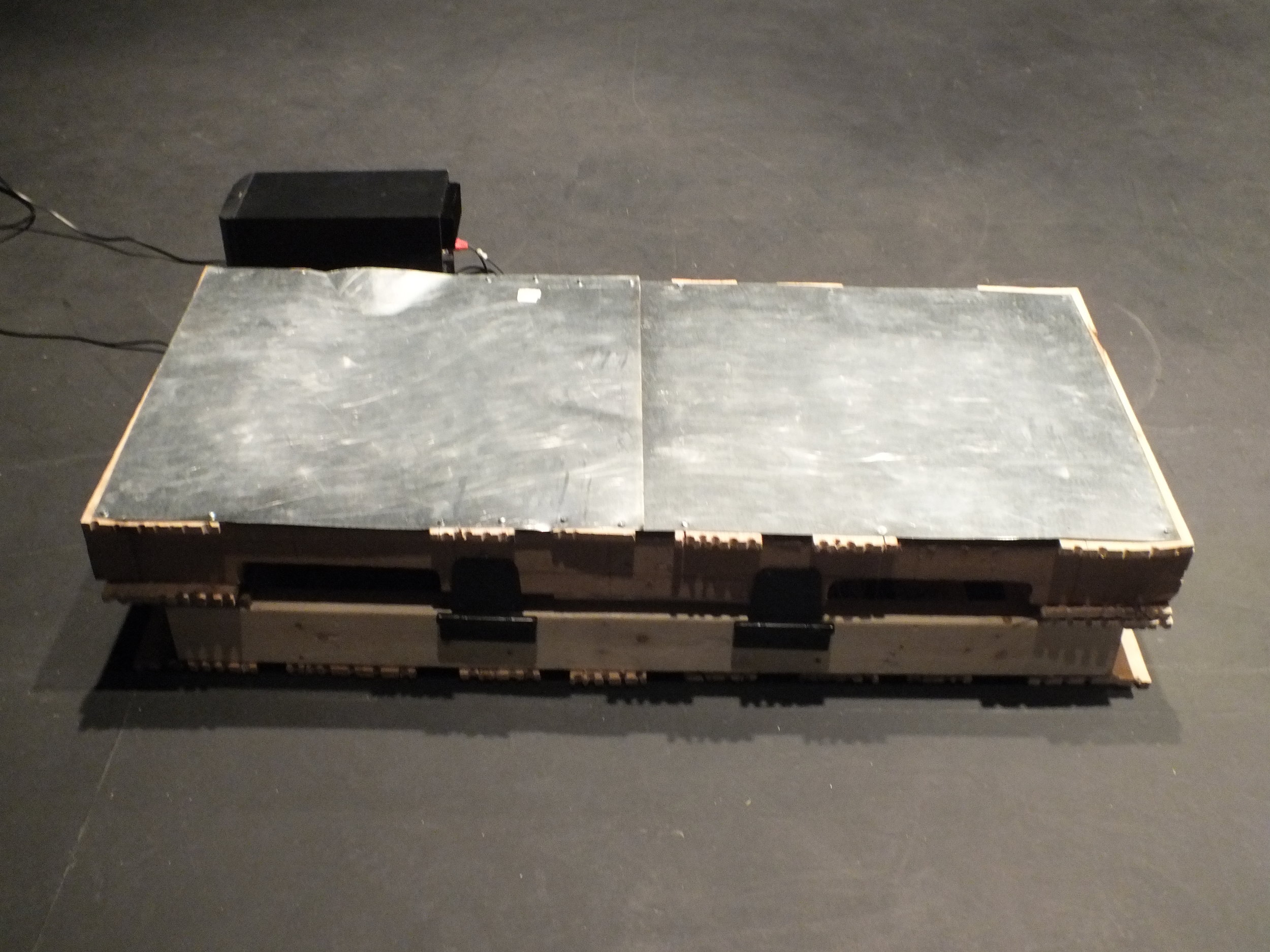 The Rack – based on the name and look of an 18th century torture device of the same name in which a victim’s limbs are tied down to be cut with swords, smashed with hammers, or stretched (Scott 1959). The Rack is a small rectangular box with a metal surface amplified with contact mics that are fed through two custom designed circuits. The two circuits are also fed through the same output which allows creates a feedback loop that falls into chaotic sounds when interrupted by sounds on the metal surface. During rehearsals for the work I captured sonic dancer Richard Lee experimenting with The Rack which can be seen here: