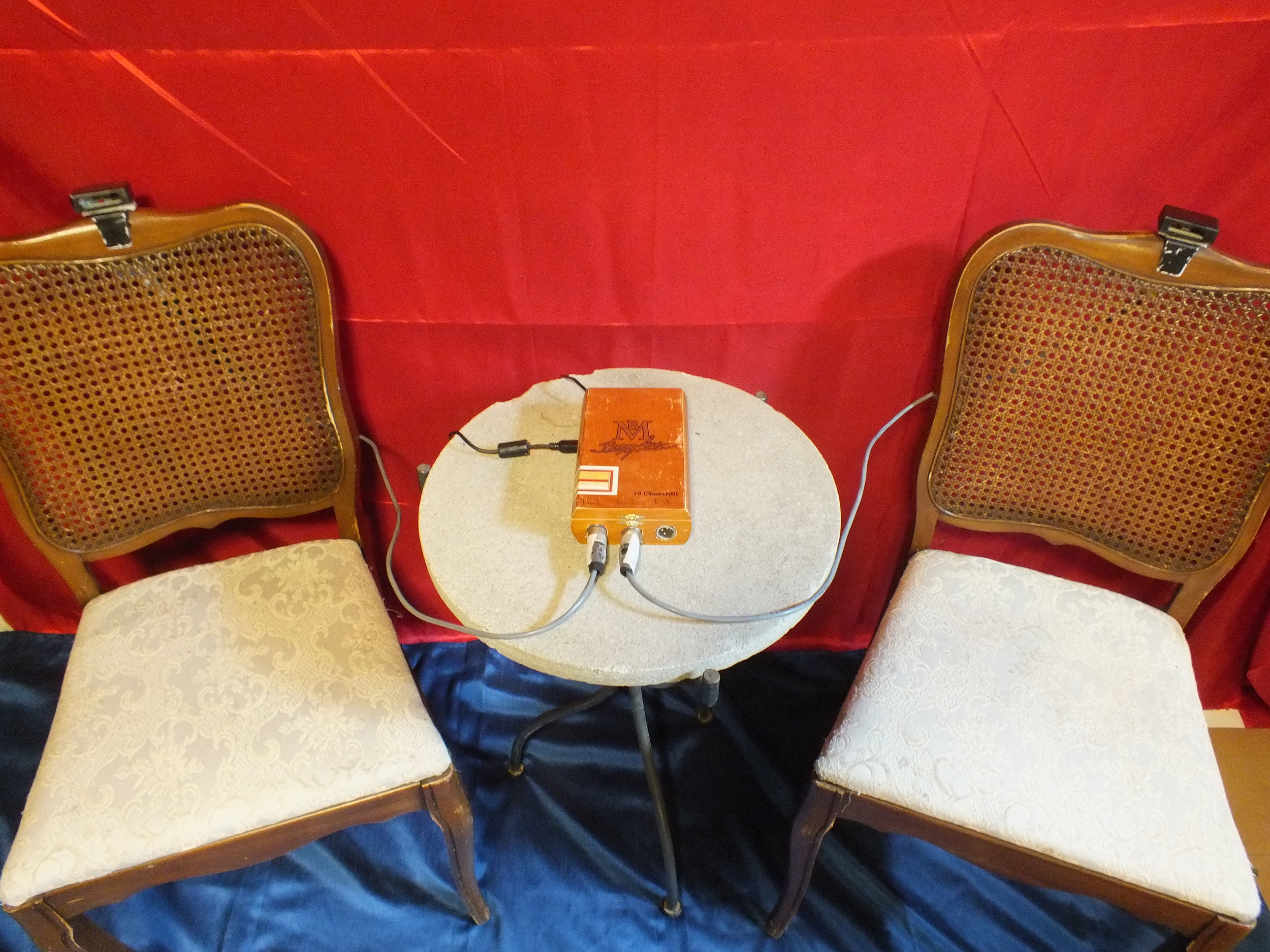 For the chairs, the next step in the process was to solve the problem of the stage lights interfering with the motion sensors. To rectify the problem, I bought small plastic casing from a local electronics hobby shop that would hang over top of the sensor as a kind of sun-visor. I then drilled small holes in the bottom for the cables and attached small plastic hooks to the casings to hang on the top of the back of most chairs.