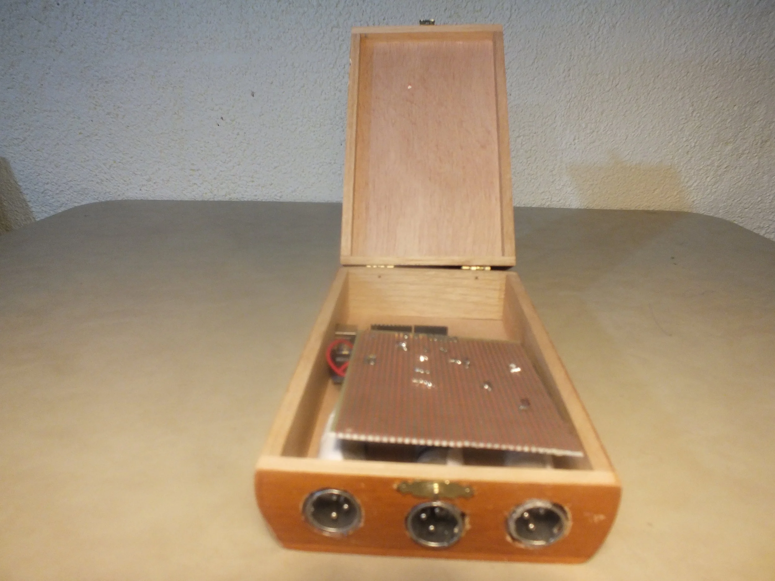 The next step was to glue the XLR jacks soldered to the prottyping board into the holes in the casing