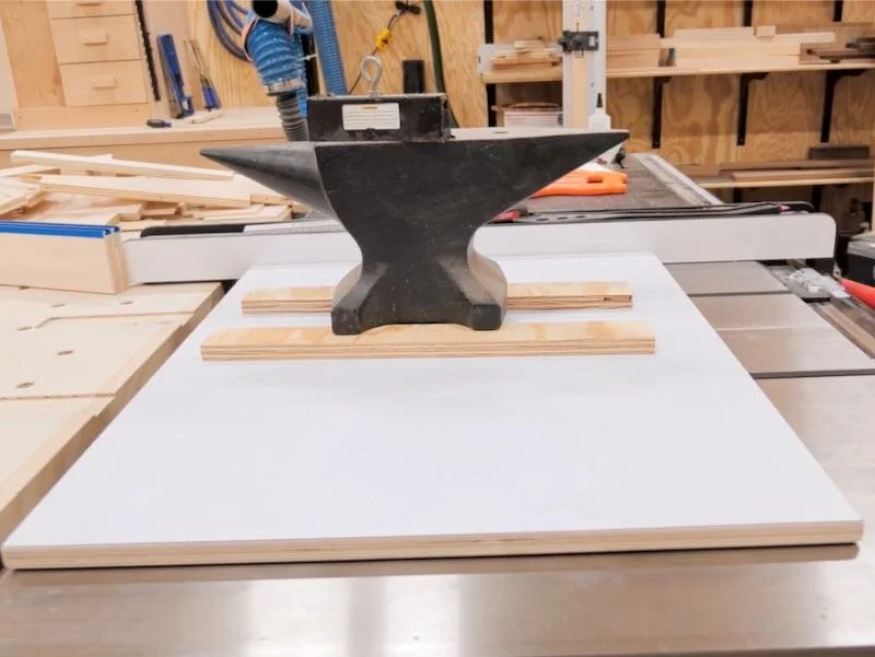 Super glue and an anvil to permanently attach the miter bars to the cross cut sled base.