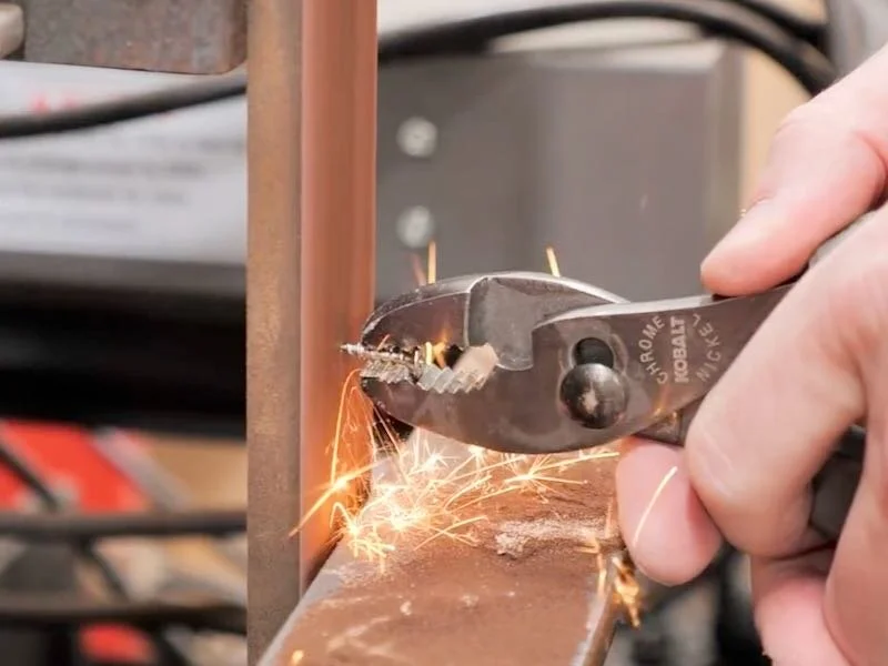Grinding screws to a shorter length using a belt grinder and pliers.