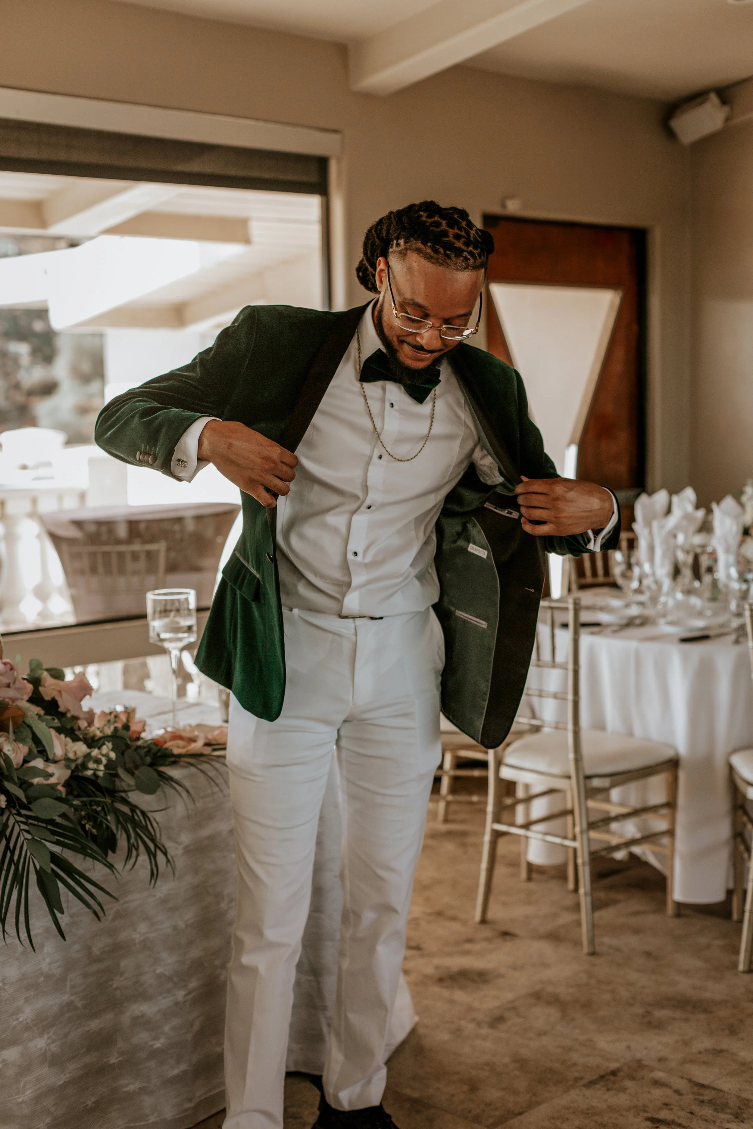 Man in tuxedo adjusting jacket at decorated event venue