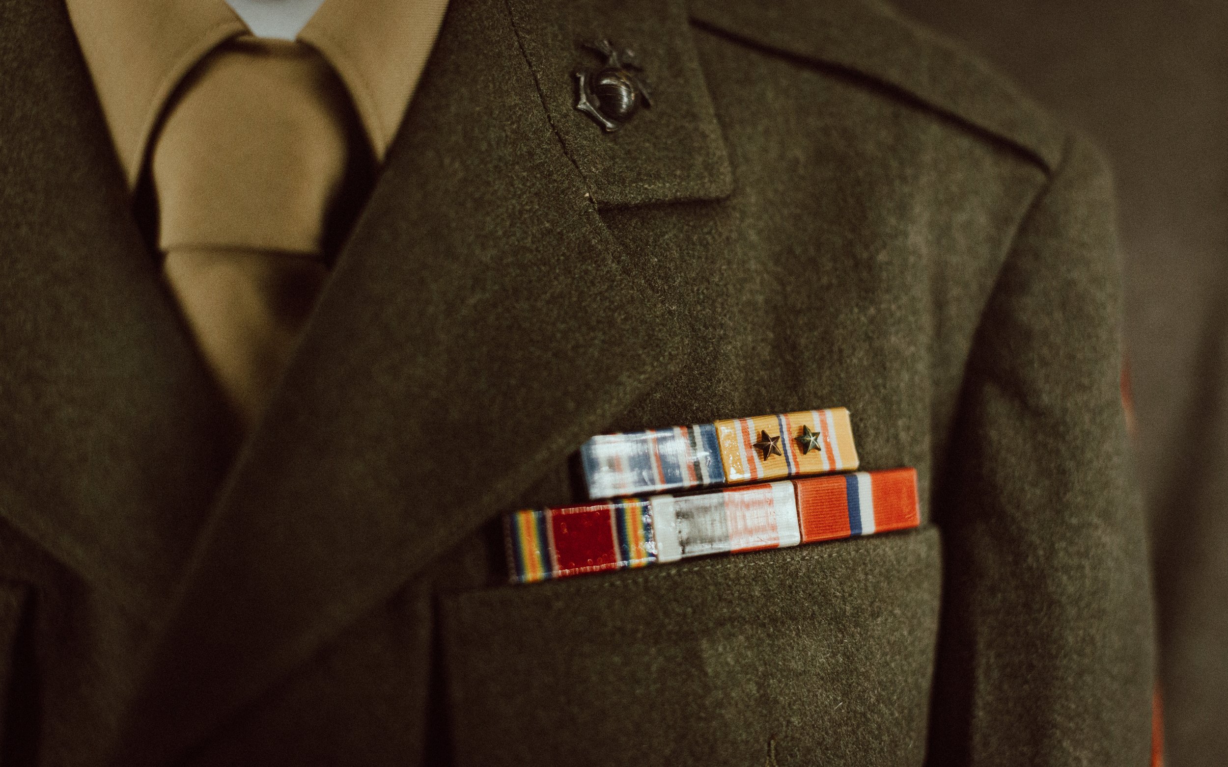 Close-up of a military dress uniform with several ribbons and medals on the chest.