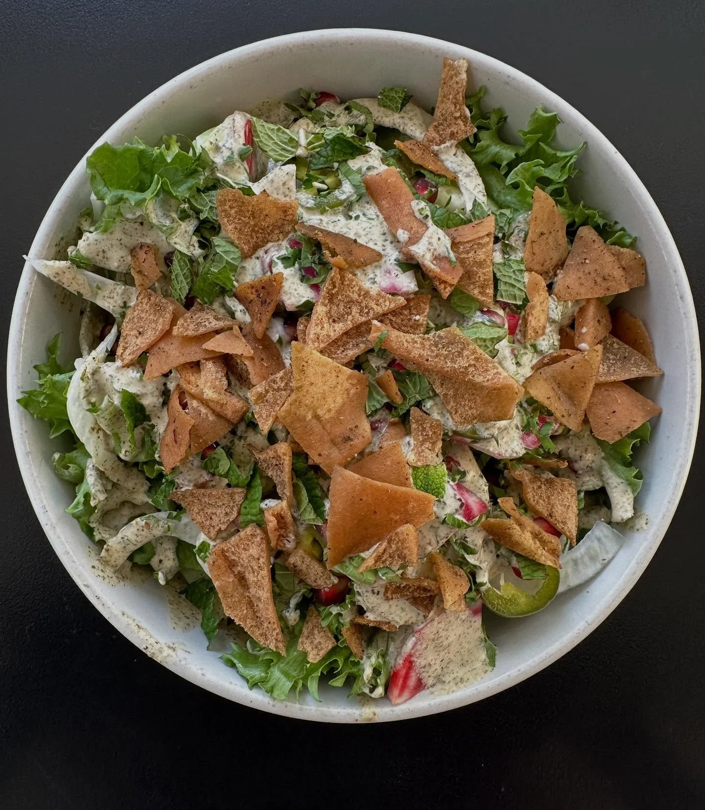 Farmers Market Za&rsquo;atar Salad, fall update: cucumber, shaved beet, fennel, pomegranate, pickled jalapeno, mint, fried pita, baby greens, za&rsquo;atar yogurt dressing. We like to add a chicken kebab on top.