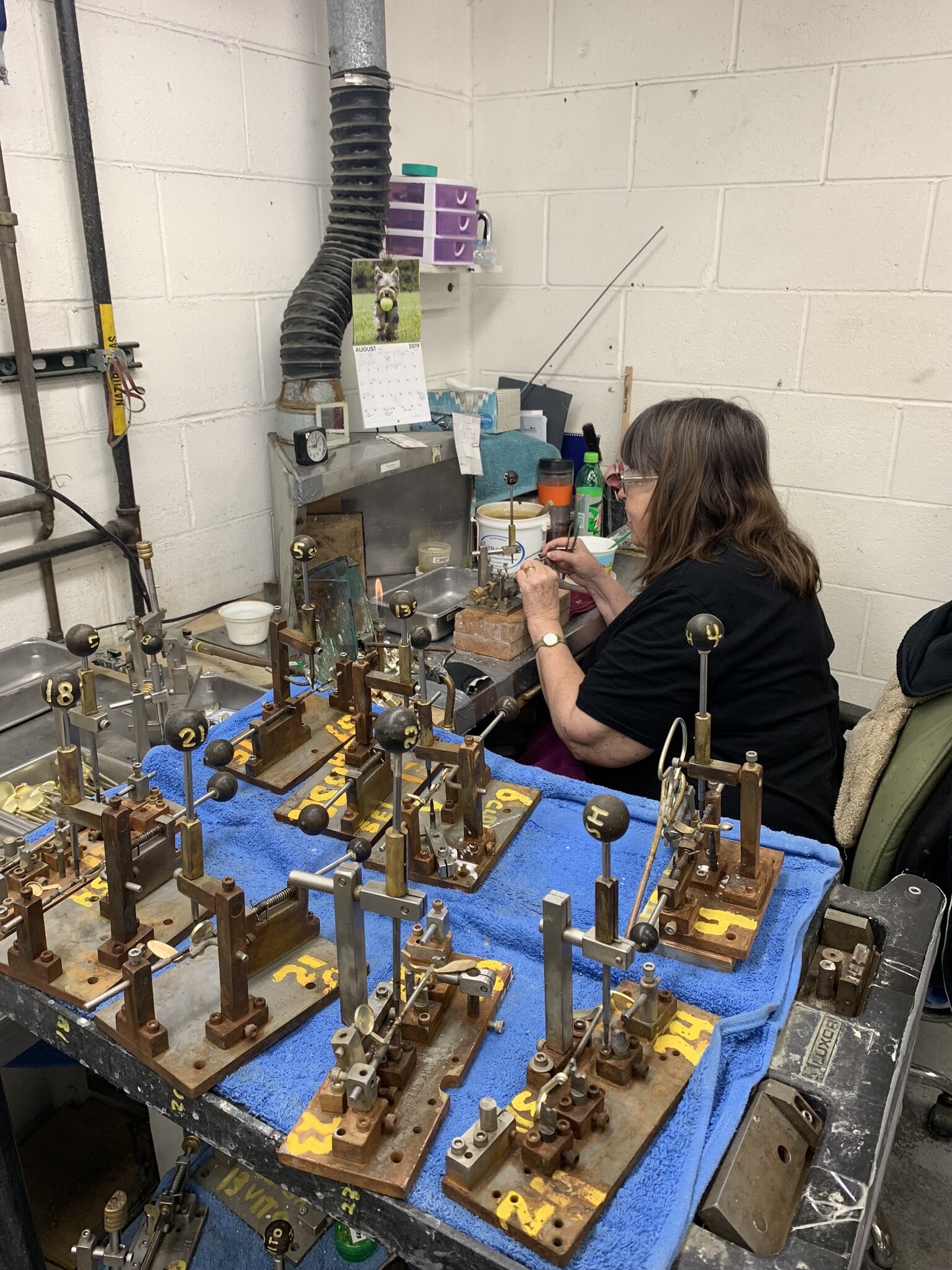 Technician soldering a spring onto an individual key.