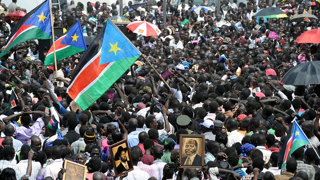 A view of people holding photos of the founding fathers of the Republic of South Sudan, President Salva Kiir (center left) and John Garang (right) during celebrations of the the first anniversary of South Sudan’s independance in 2012. Photo by: Staton Winter