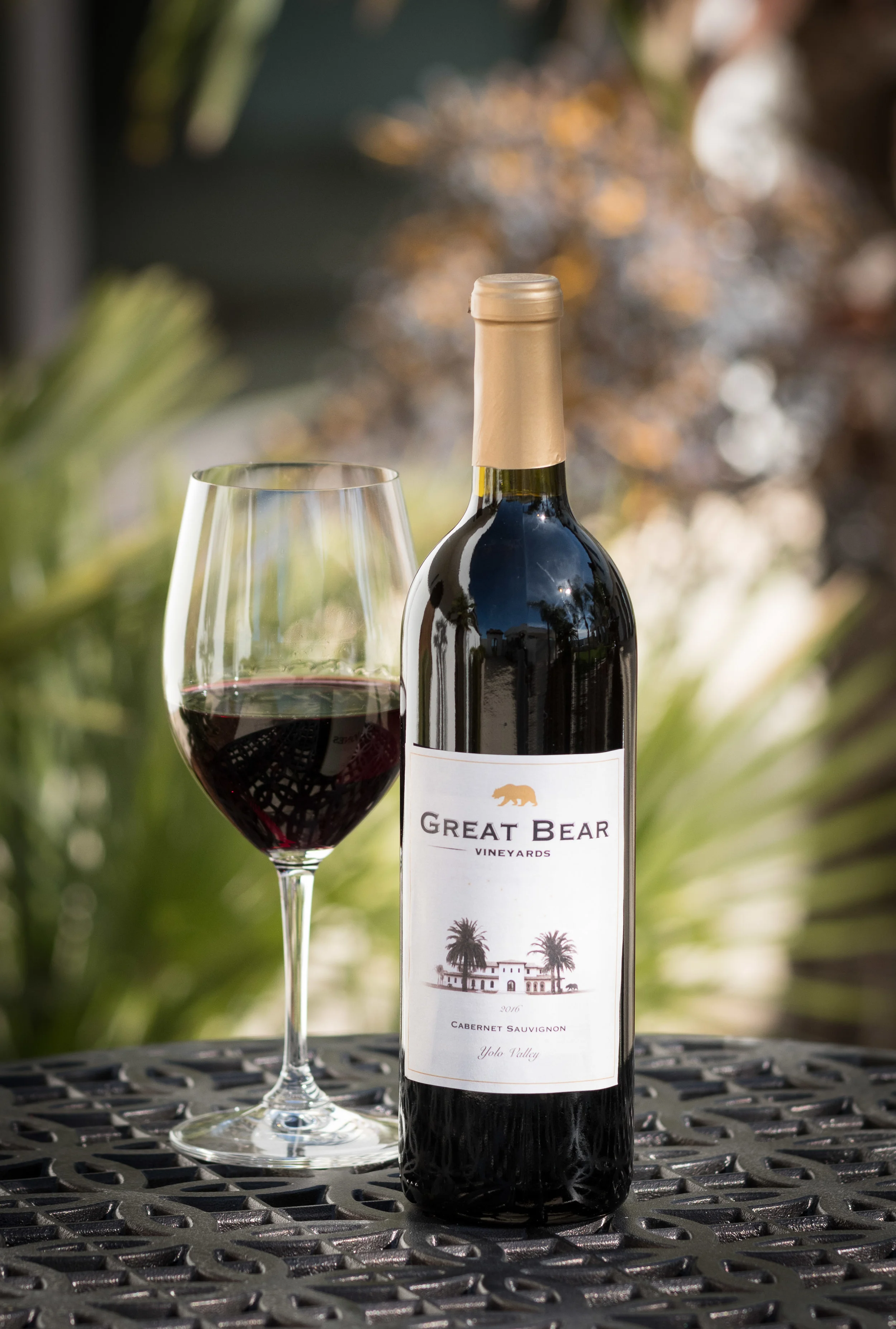 Glass of red wine next to a bottle of Great Bear Cabernet Sauvignon