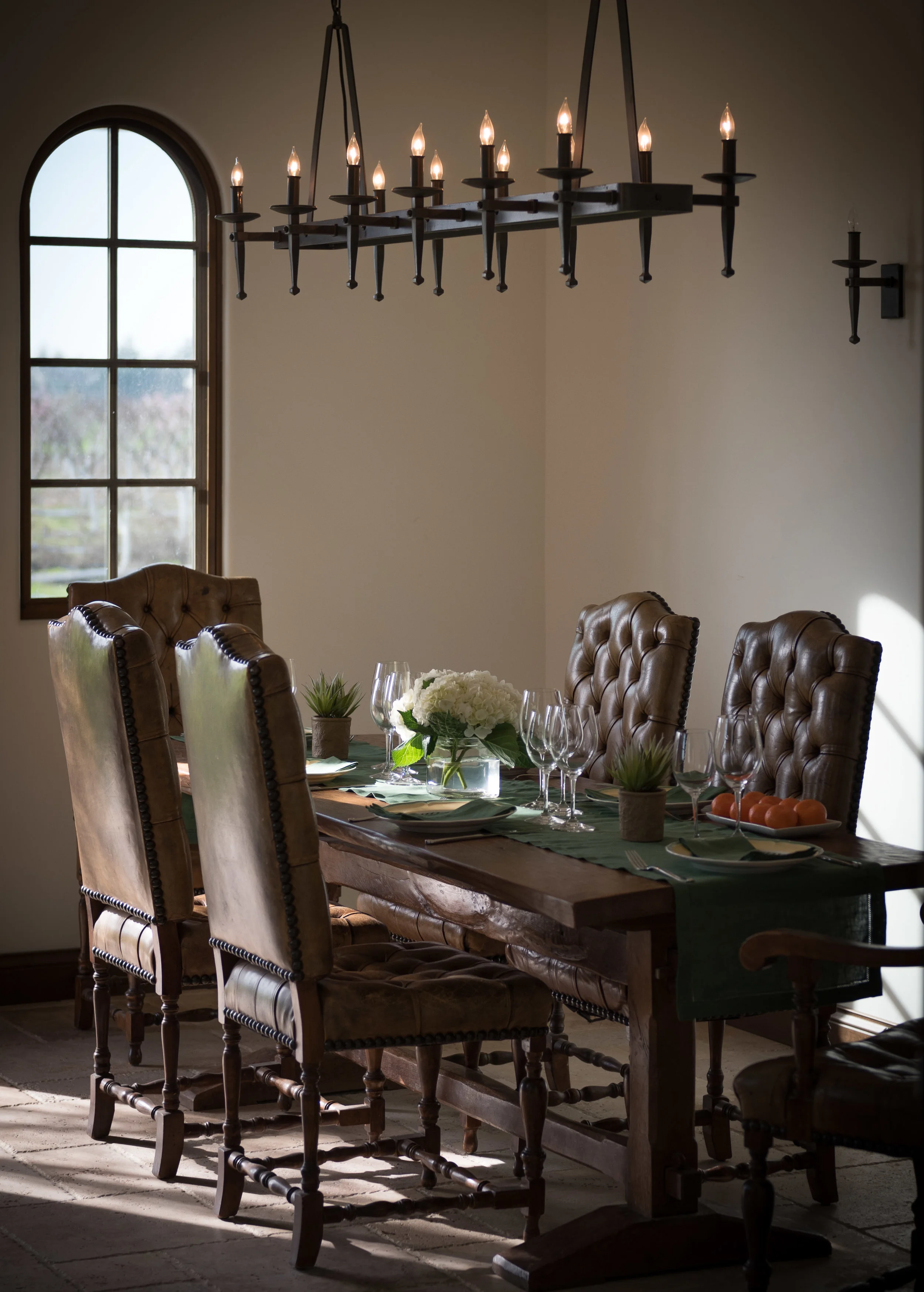 Chairs around a wooden table with a chandelier above