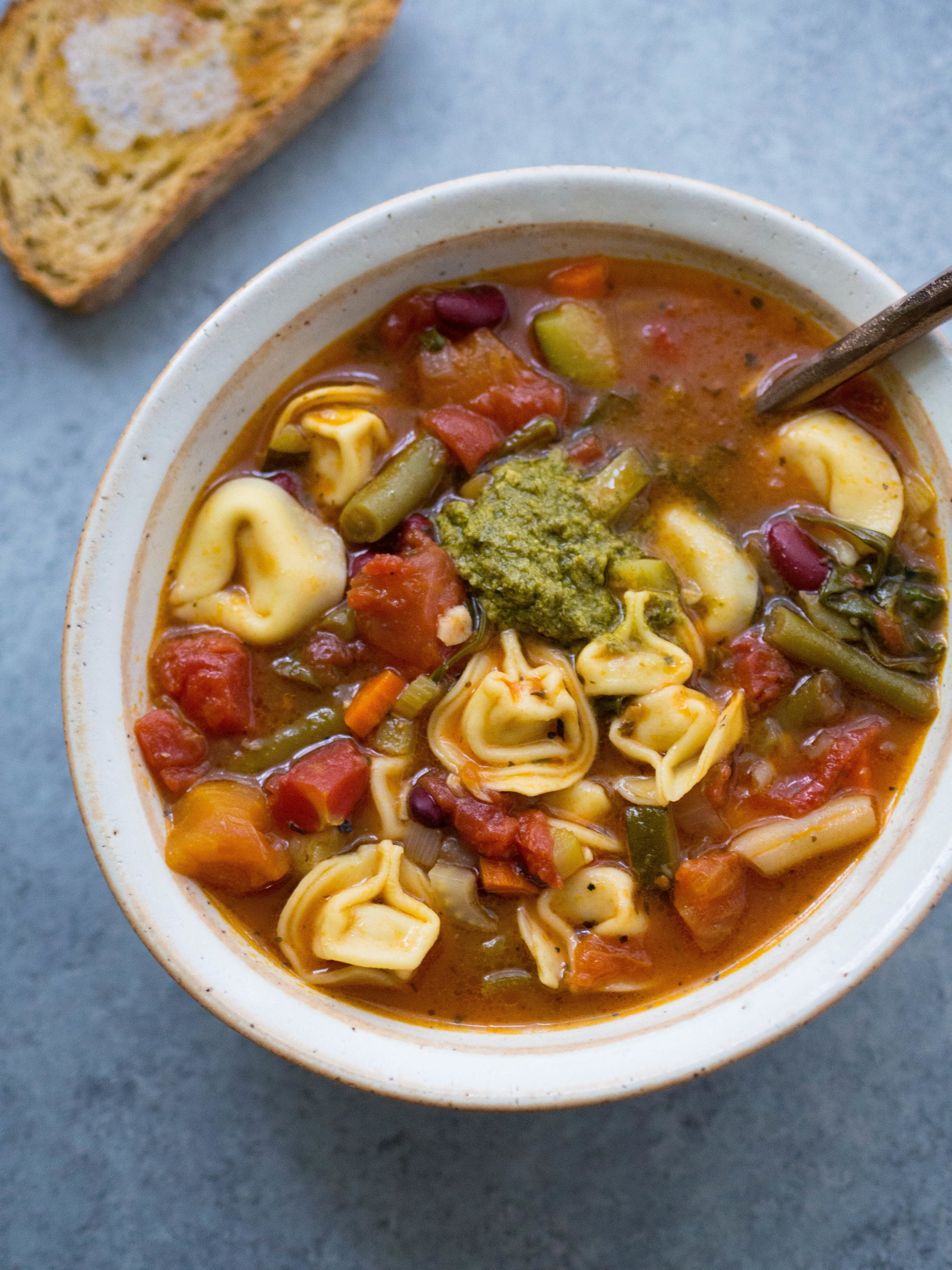 This Three Bean Tortellini Minestrone tastes like it’s been simmering all day, but you can make it in just over 30 minutes! #soup #tortellini #minestrone #minestronesoup #vegetarian #healthydinner