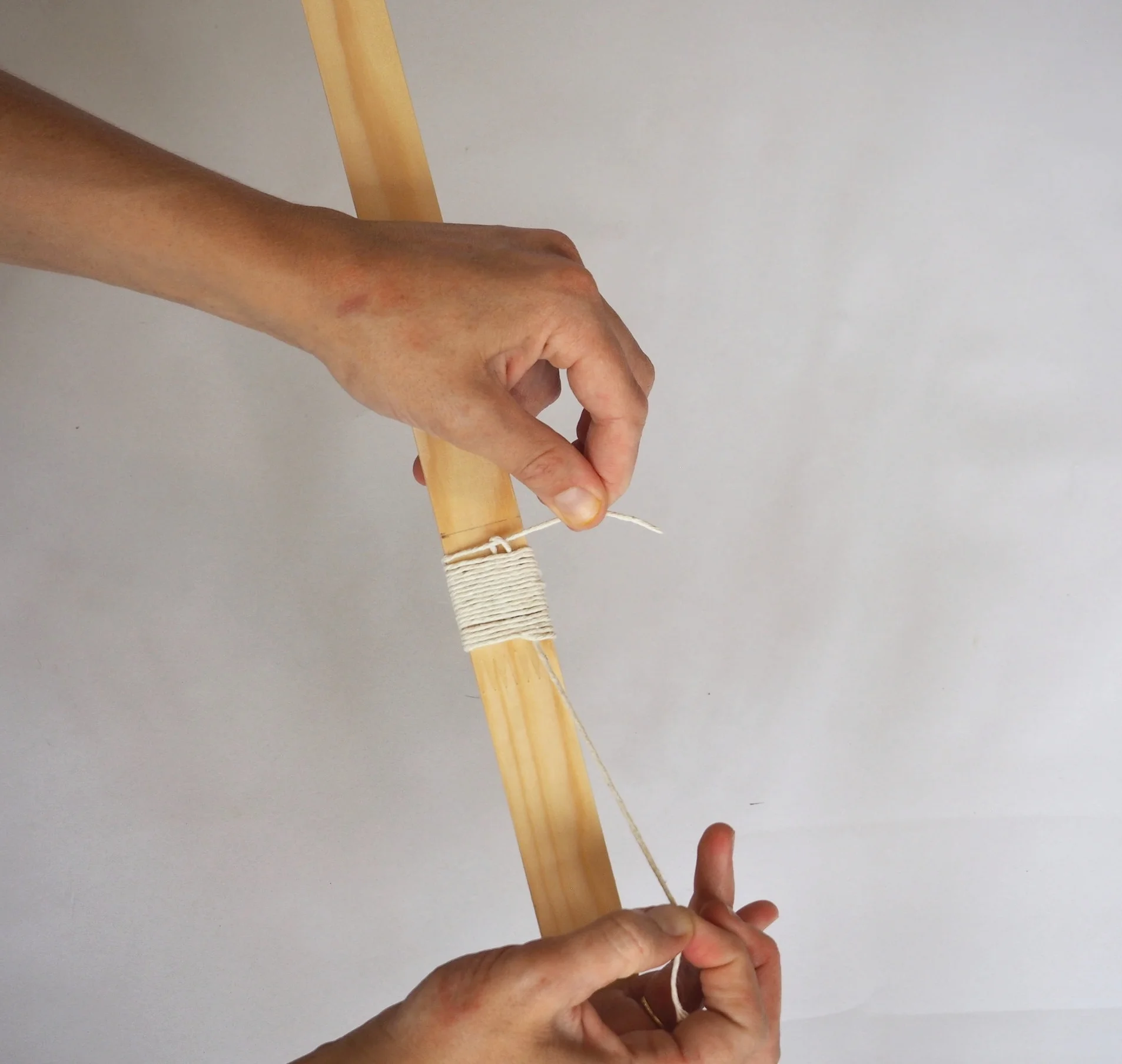  Keep pulling on the end of the loop until the top of the loop disappears behind the binding.  