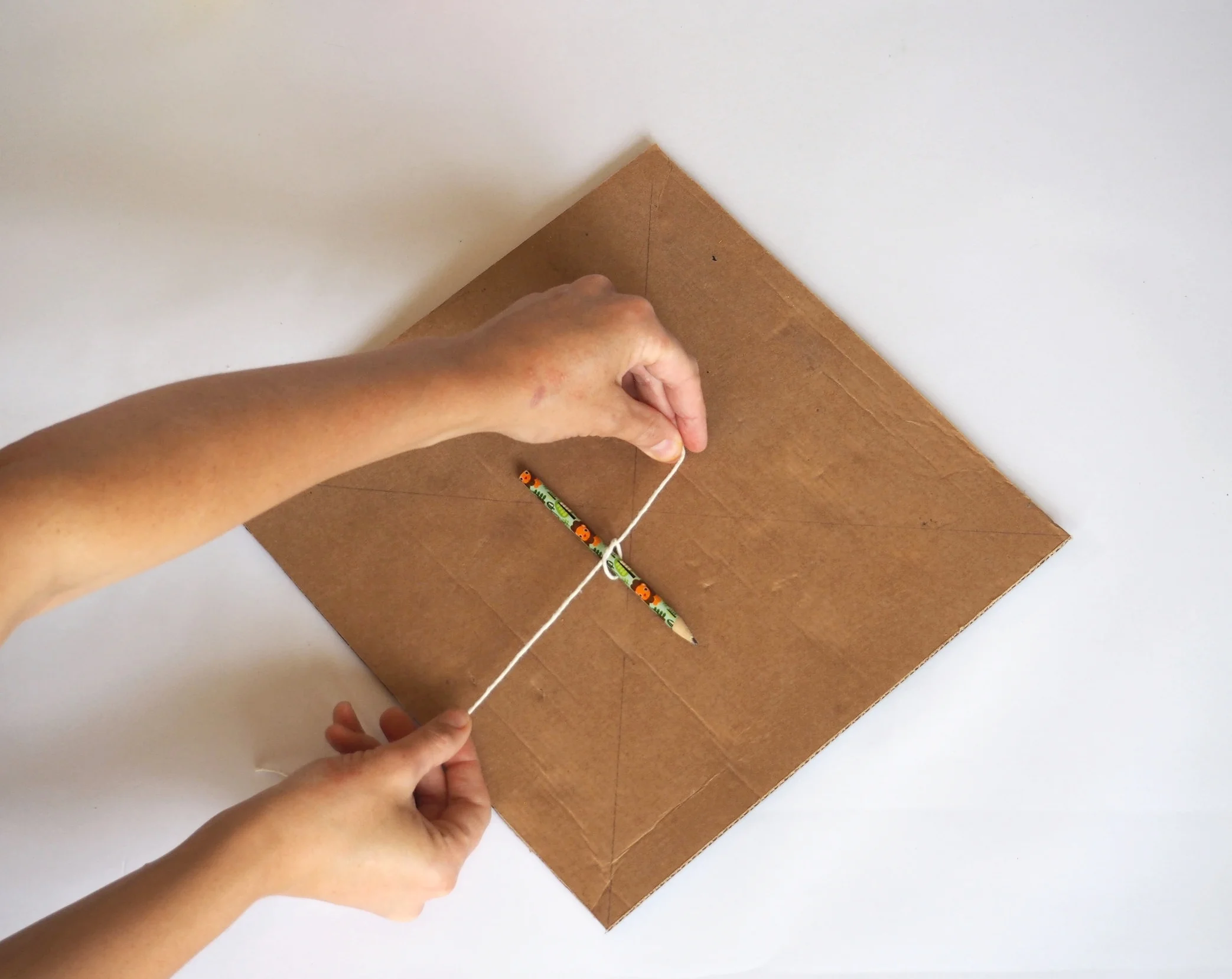  Tie the 15cm length of sting around the pencil 