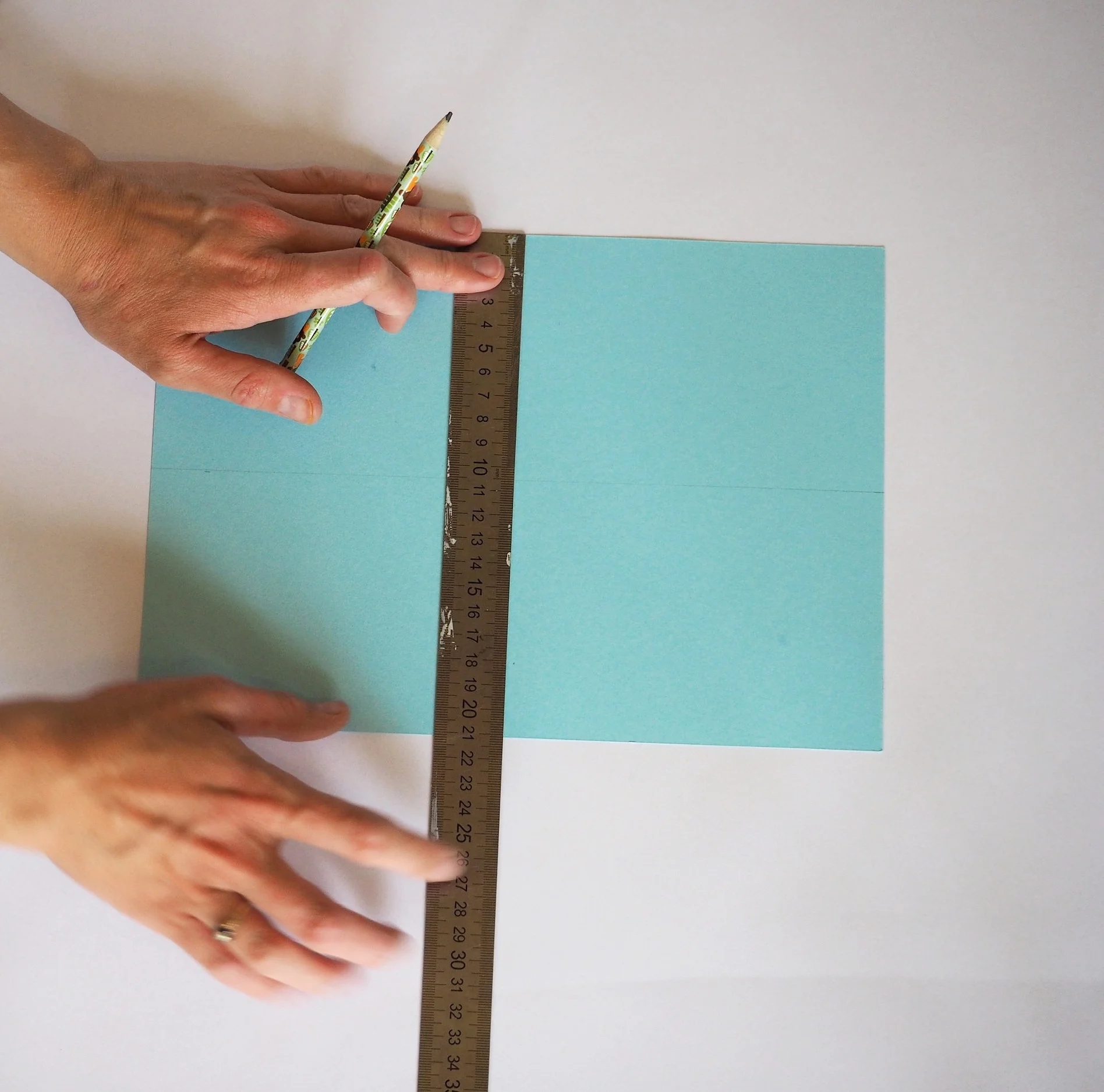  Take your thin piece of card and draw a cross through the centre of it. 