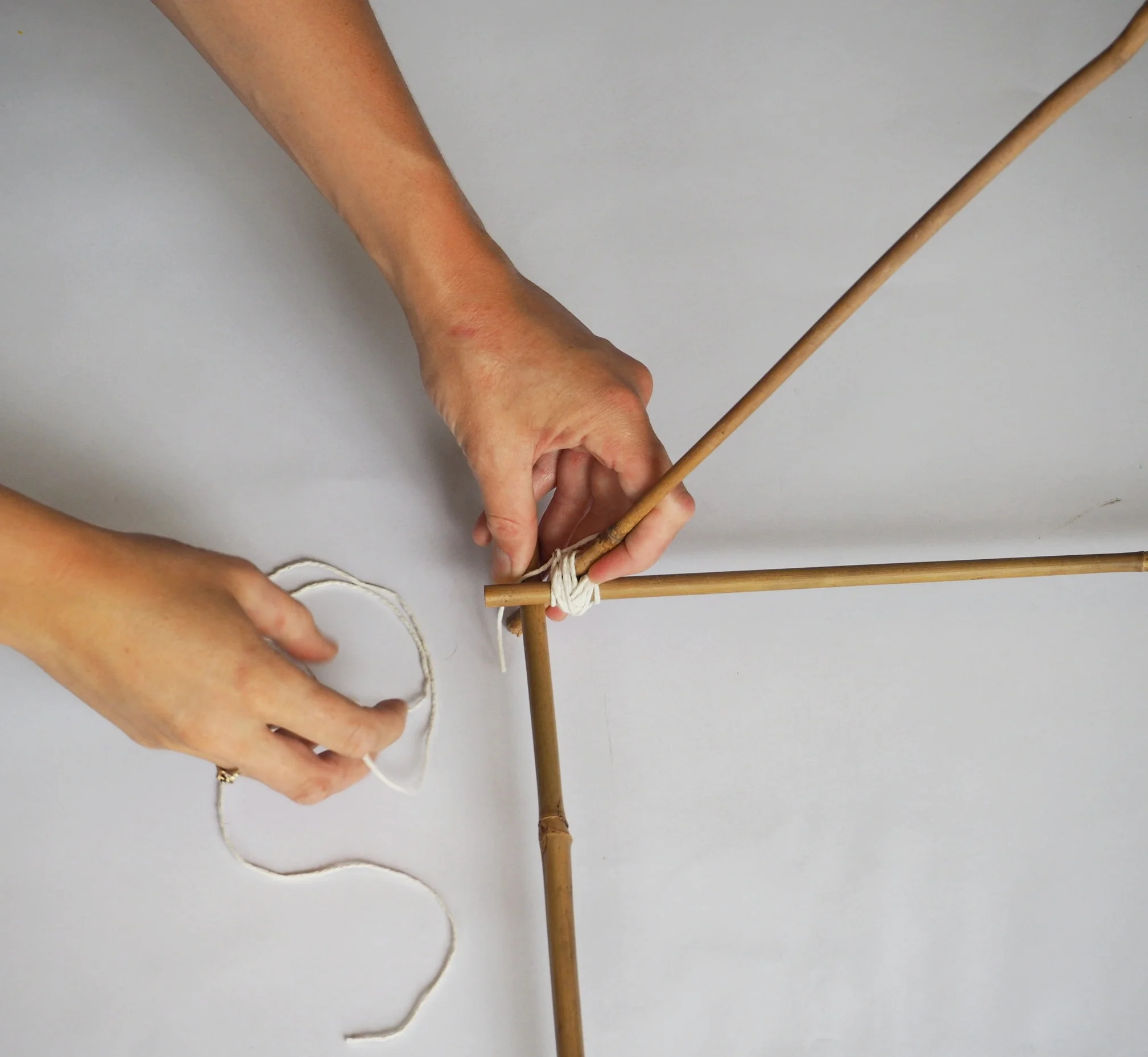  Stand one of your triangles up and take the longest cane (160cm) and slot it into the V between the two short pieces of cane after the join.  