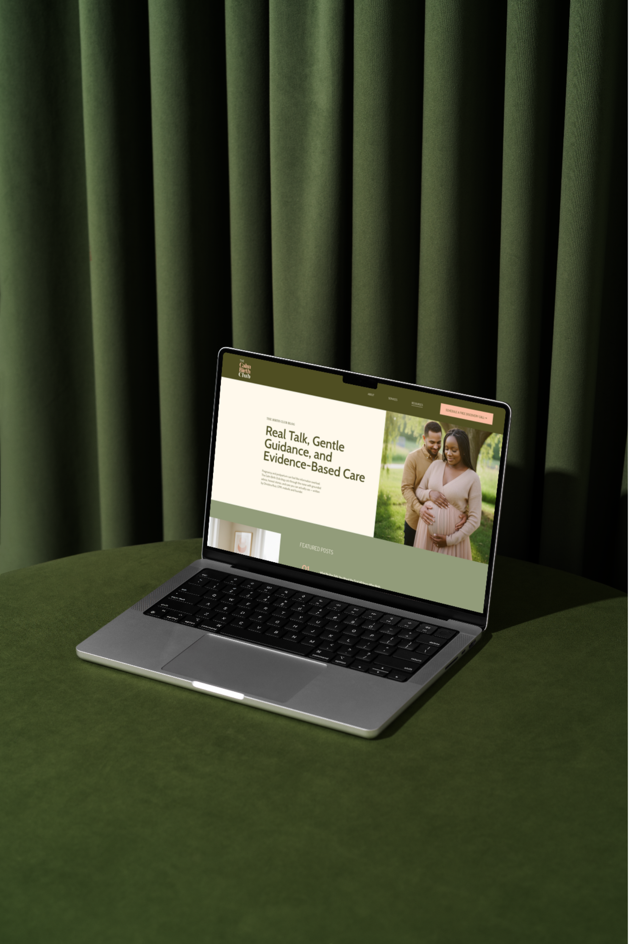 laptop sitting on a green round table with a match green curtain behind it