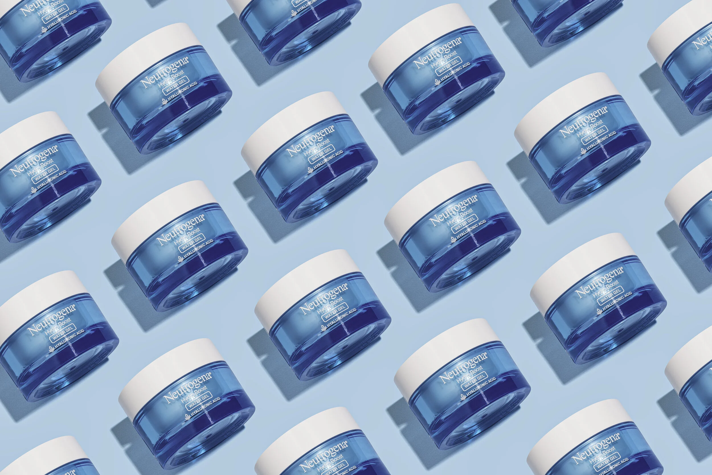 Multiple jars of Neutrogena Hydro Boost Water Gel skincare product arranged on a light blue background.