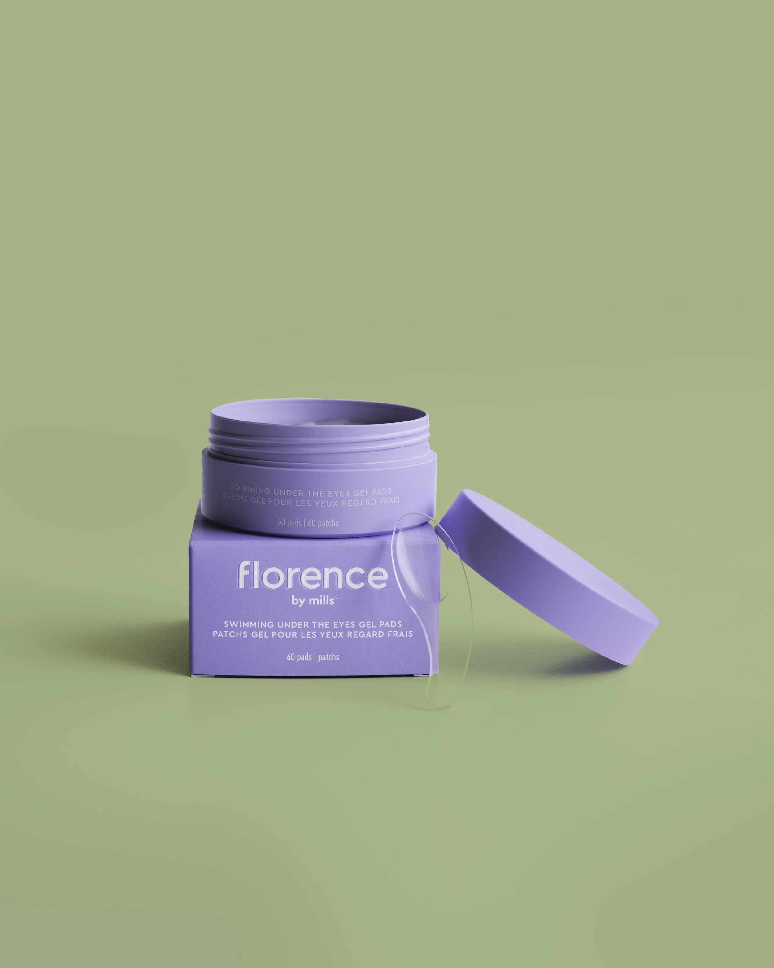 Open purple container of Florence by Mills swimming under the eyes gel pads with lid resting against the container on a light green background.