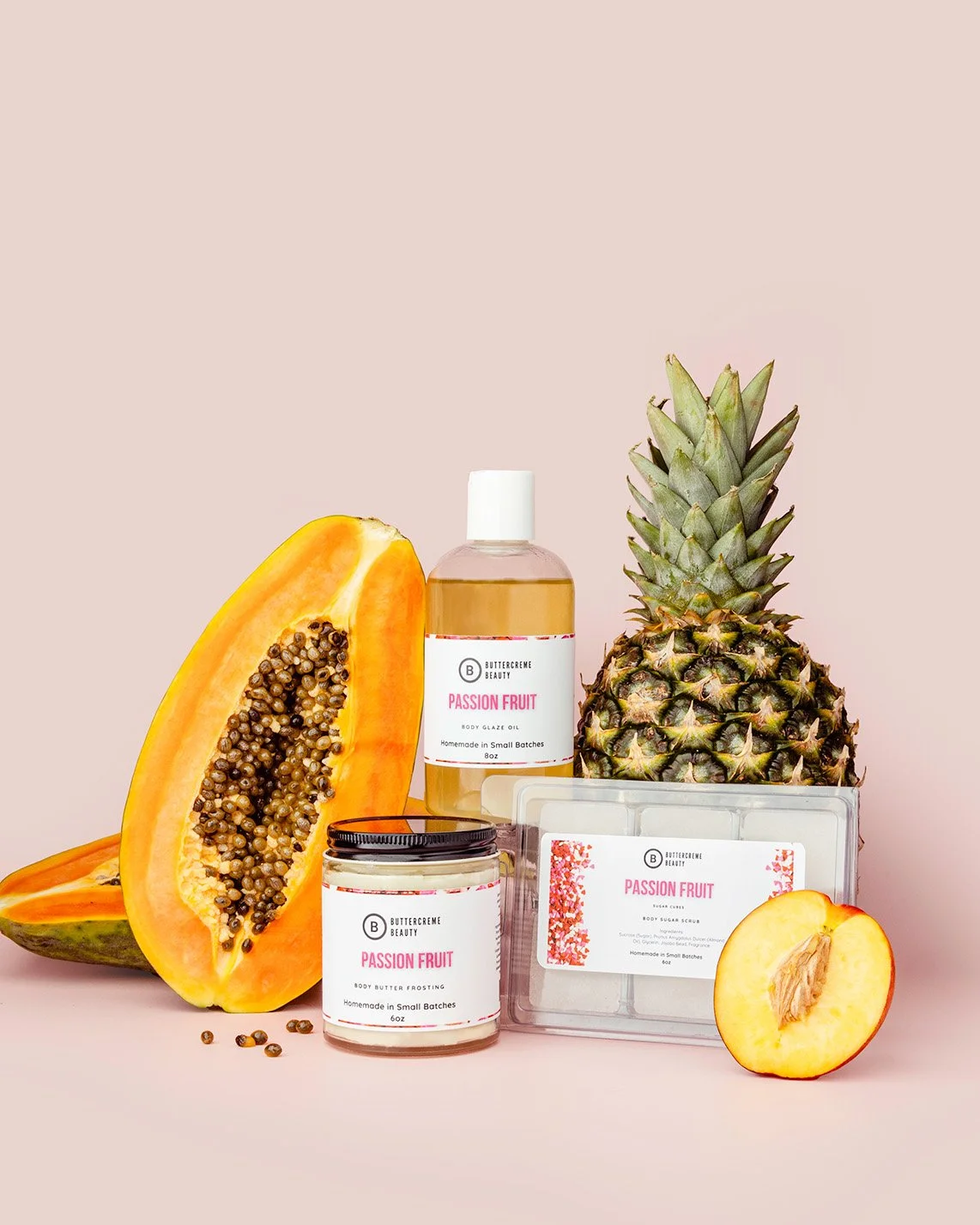 Skin care products with passion fruit, a pineapple, and a papaya on a pink background.