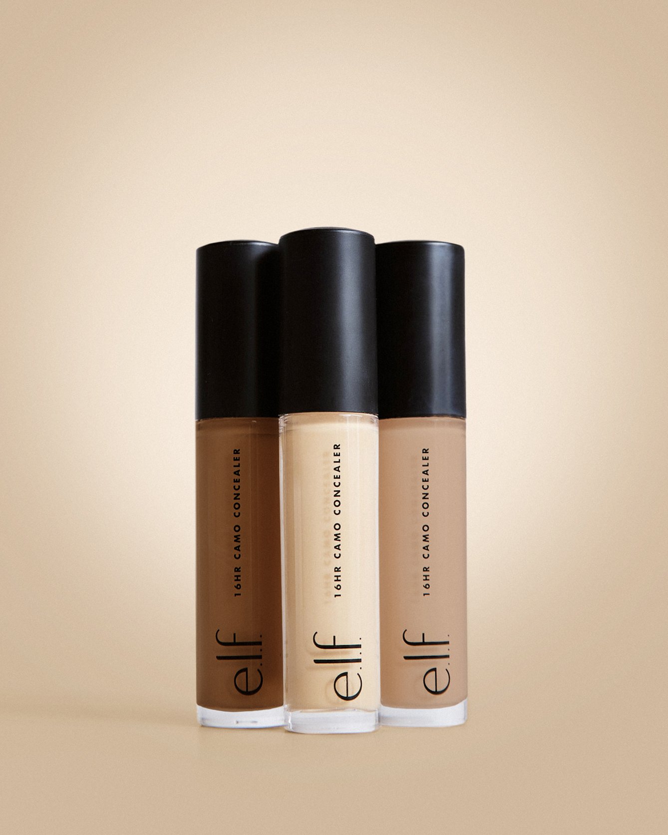 Three tubes of e.l.f. 16-hour camel concealer standing upright on a plain beige background.