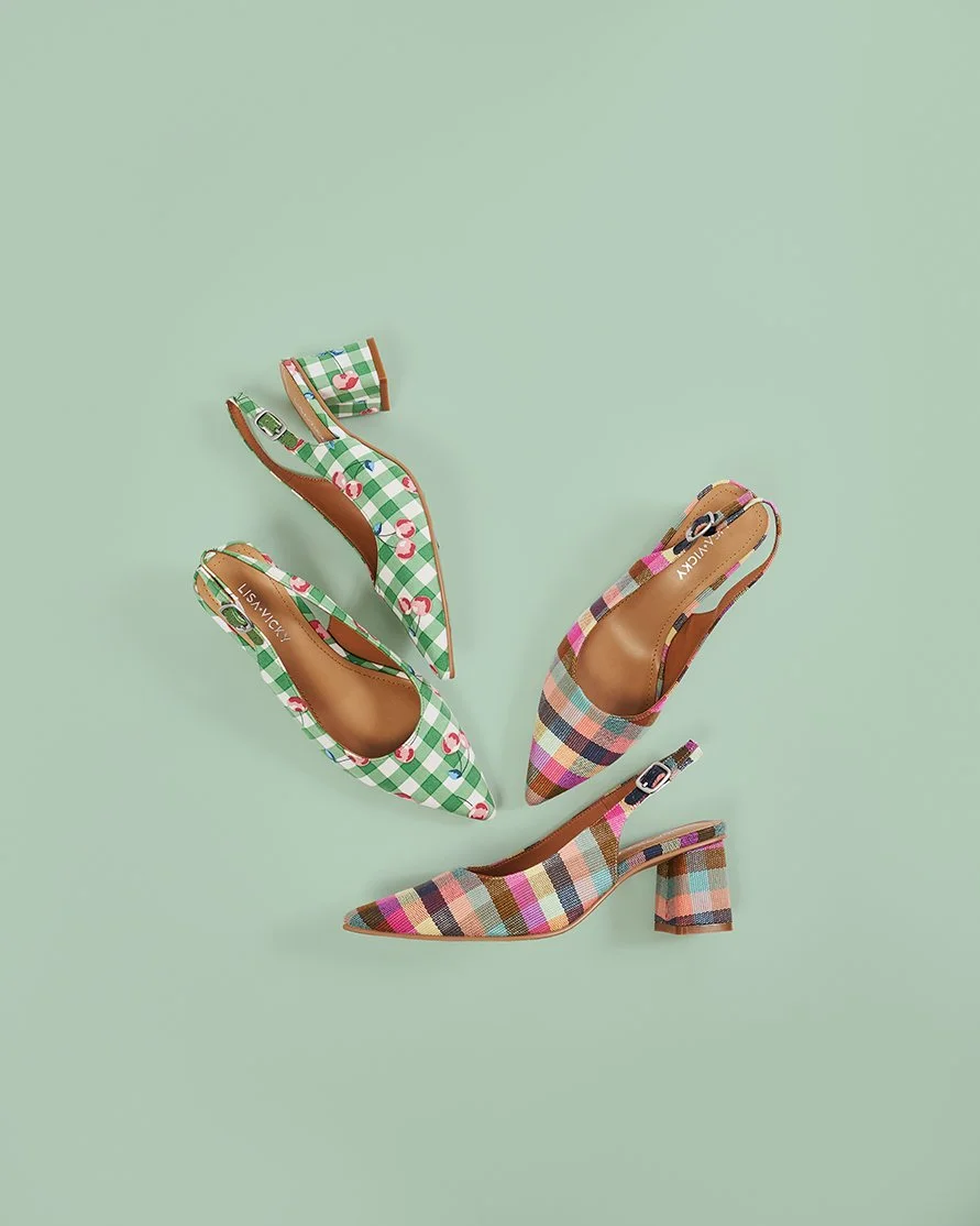 Three patterned high-heeled shoes on a mint green background.