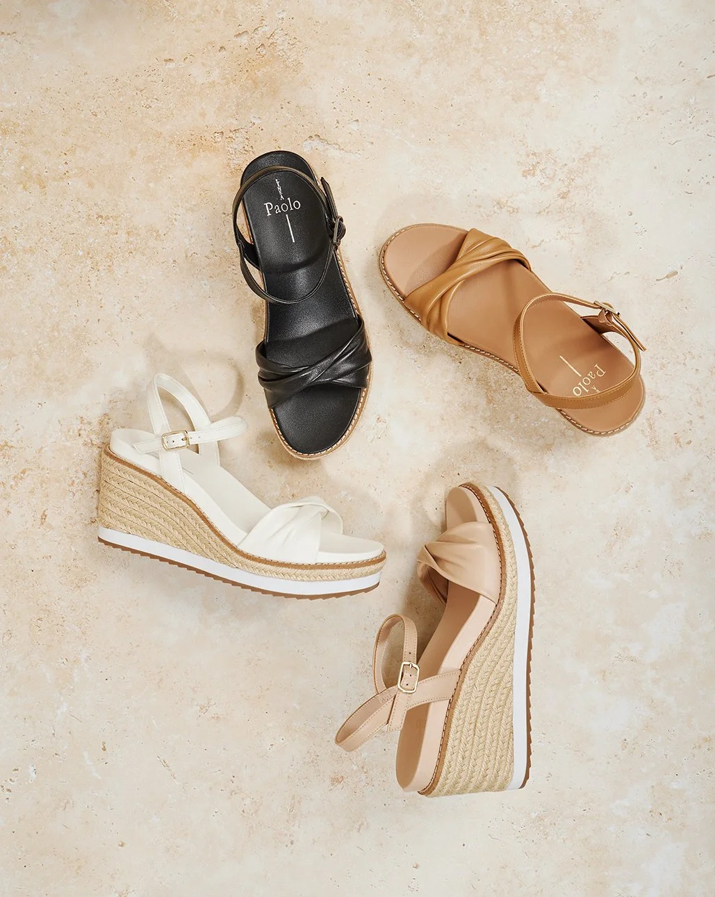 Four pairs of women's wedge sandals arranged on a beige tiled floor, in black, tan, white, and light pink colors.