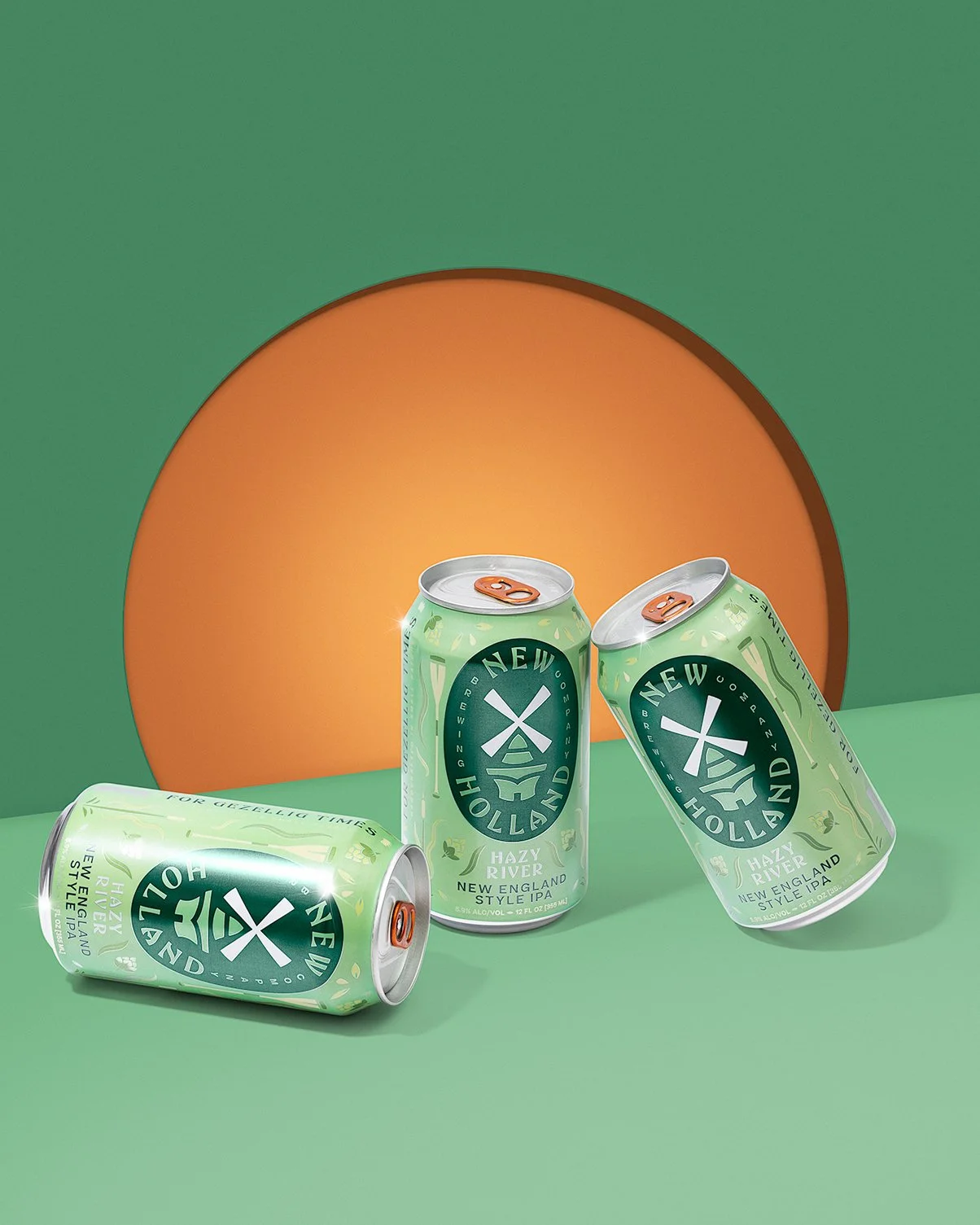 Three cans of New England Style IPA beer from Hazy River Brewing Company, with one can lying down and two standing, in front of a green and orange background.