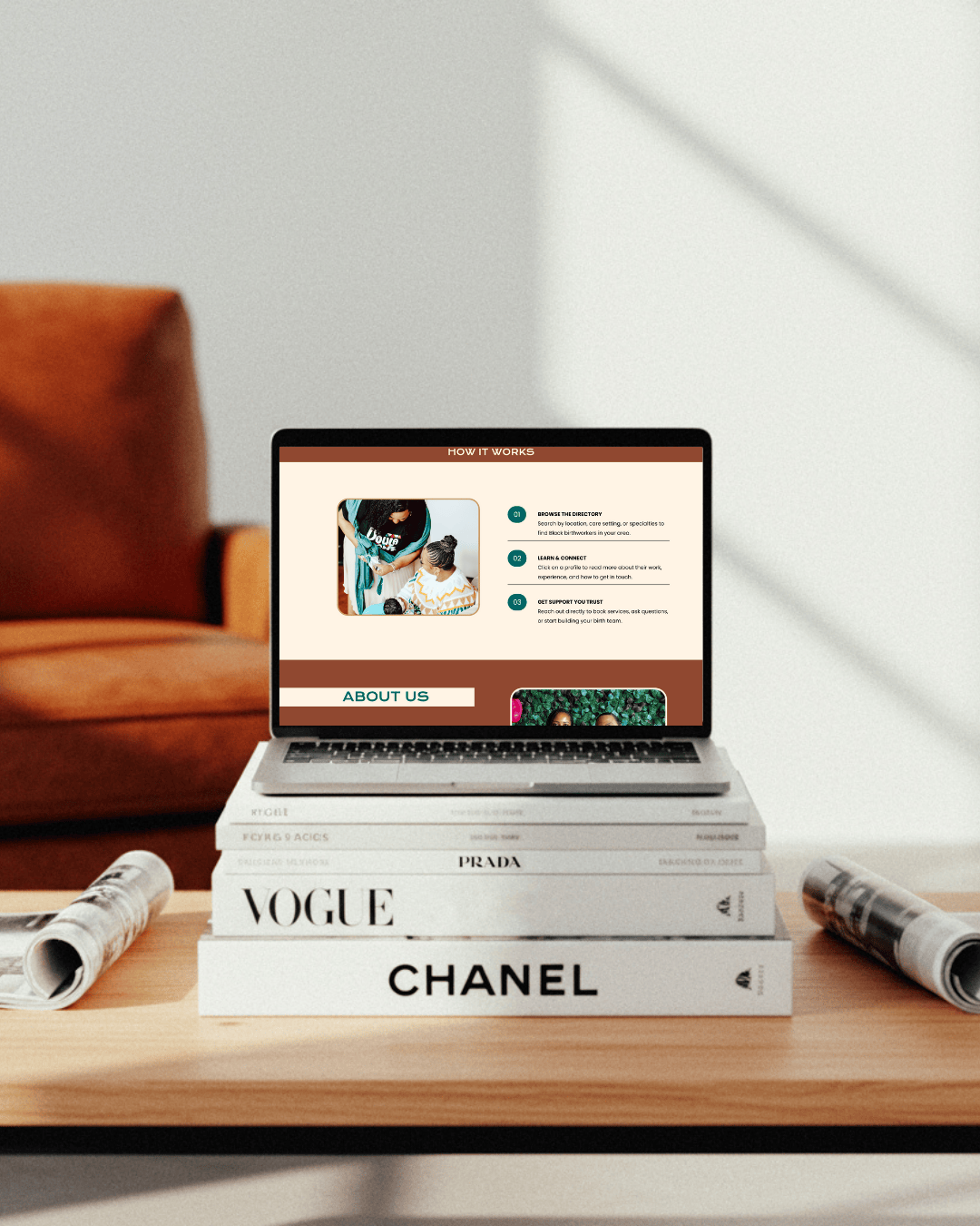 Laptop sitting on a stack of fashion books and magazines