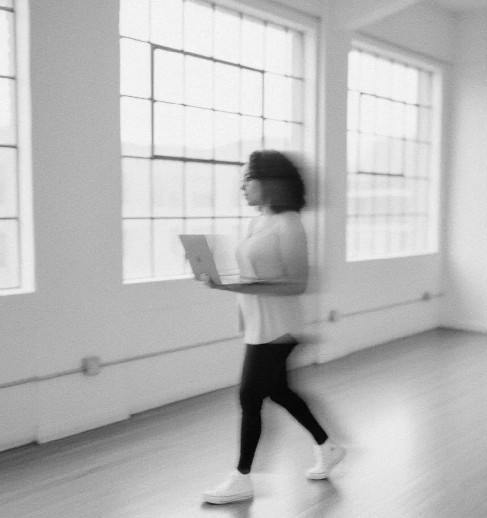 woman walking with laptop in her hands