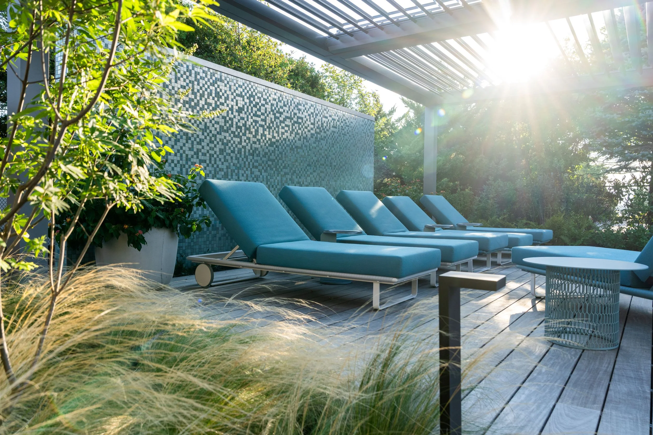 Shaded lounge deck with louvered pergola, ornamental grasses and path lighting, designed by Alan Tufts Landscape Architecture for a barrier island residence in Ocean County, NJ