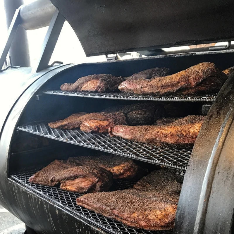 Briskets smoking on one of the huge offset smokers in the back