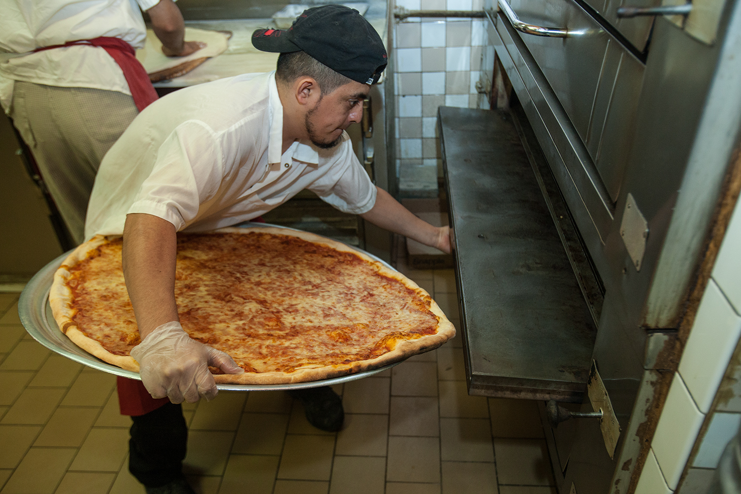 Pizzamen at Koronet combine solid gripping and body girth to maneuver pies into the oven. 