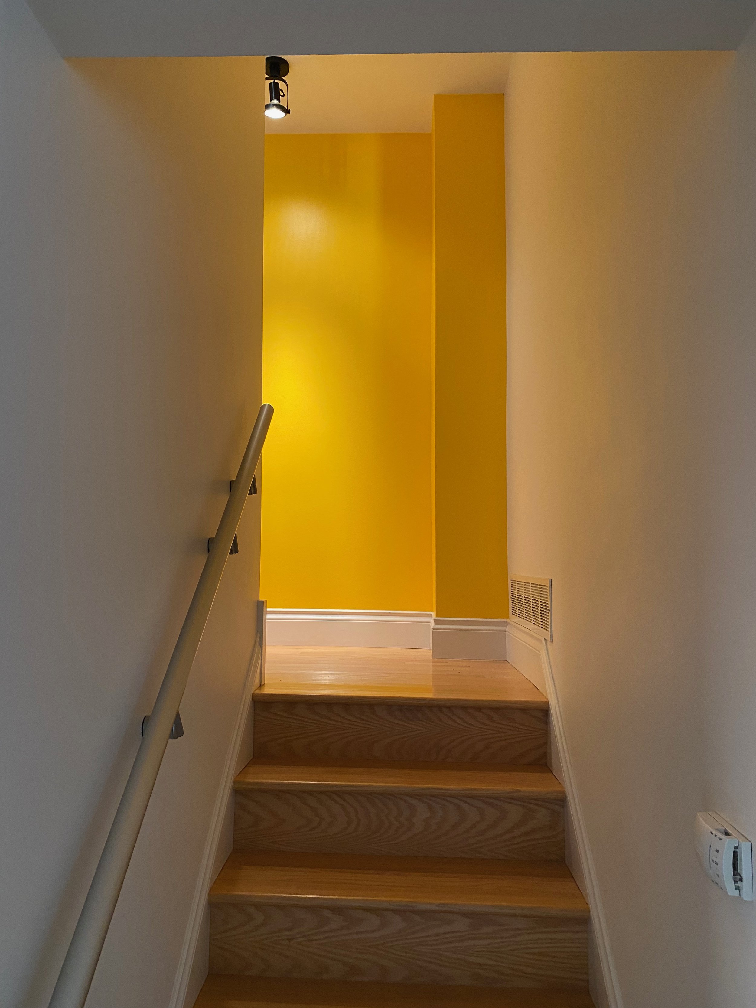 Interior stair landing painted in bright yellow