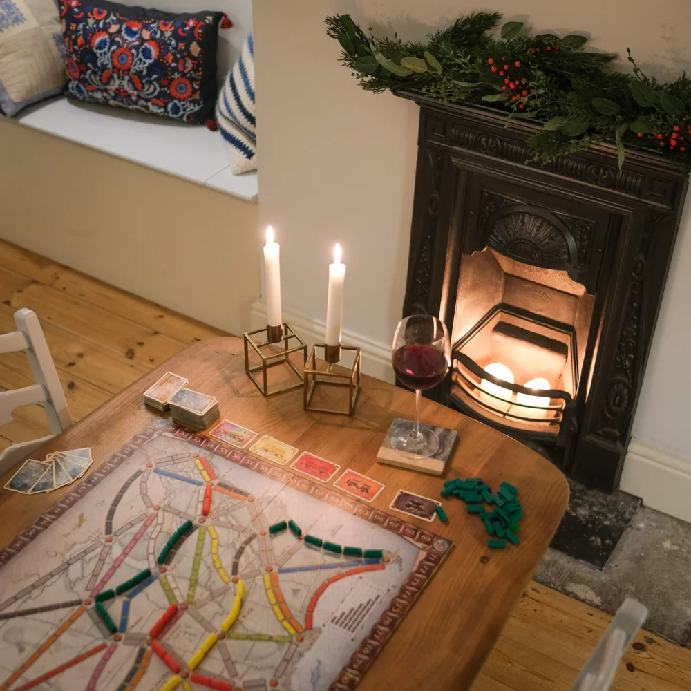 Ticket to Ride game with candles and wine