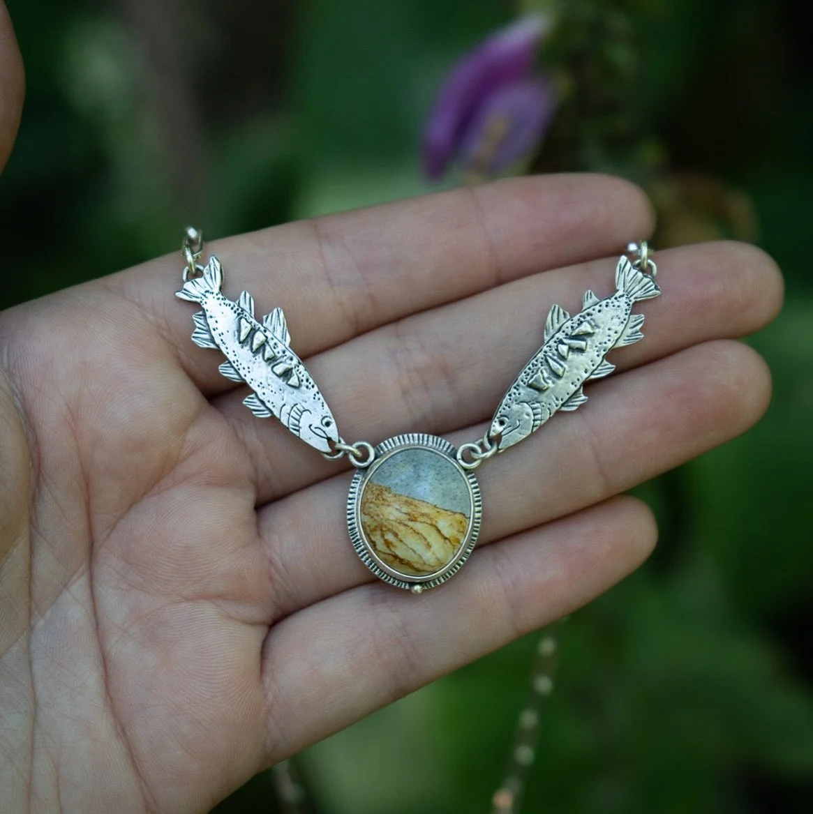 The first piece for July&rsquo;s collection! A tribute to wild waters and quiet strength 🐟 

This hand fabricated necklace features two trout, hand sawn and stamped from sterling silver, swimming toward a warm toned Chicken Track Jasper from Oregon.