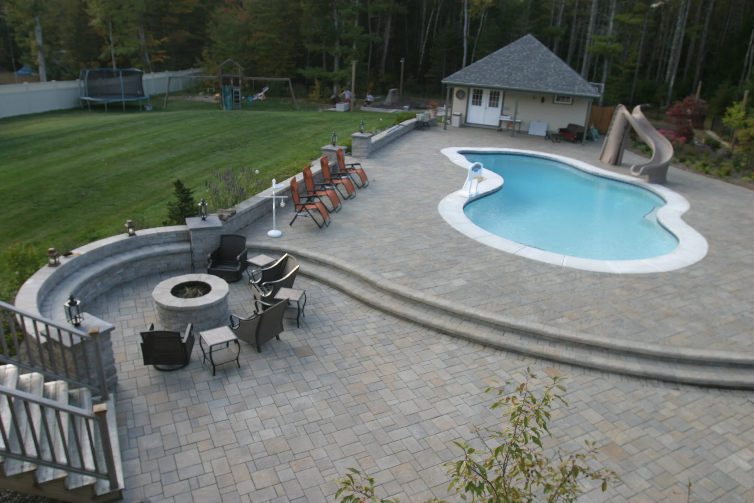  Scarborough Maine. This backyard retreat. Features Techo Bloc Products, Blu Champlain Grey, Mista Champlain Grey, Mini Creta Pillars, Tundra Caps, Aged Caps, Mini Creta walls and fire pit.&nbsp;  The patio in the foreground was constructed on a perm