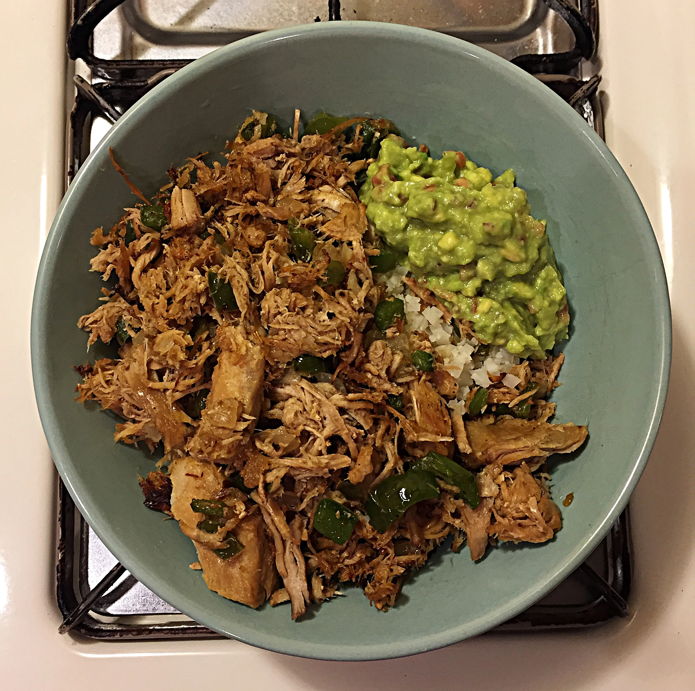 Carnitas with green bell pepper, onions, served on a bed of riced cauliflower and homemade guac!