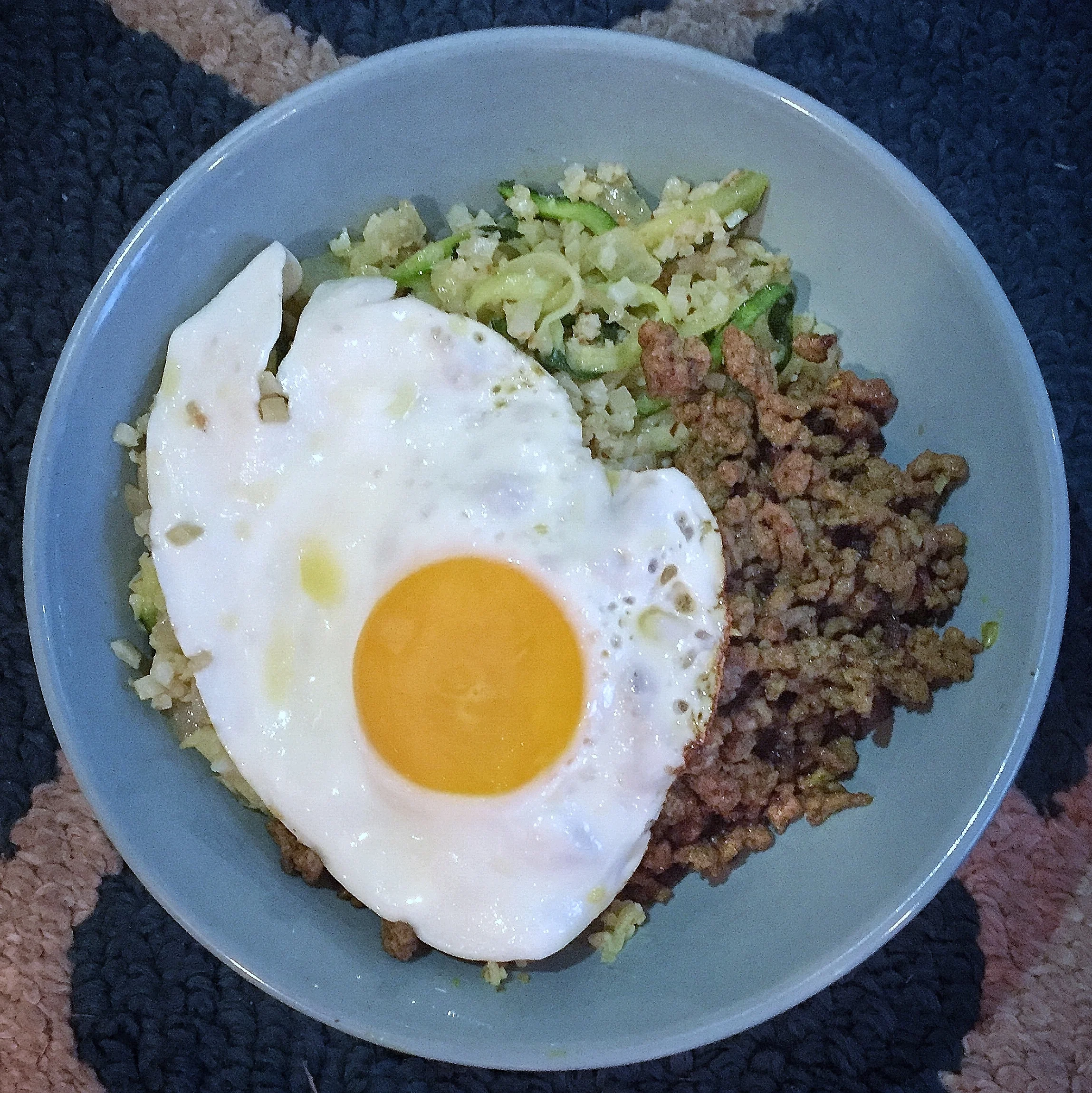 Ground beef seasoned with curry and mixed with zoodles (zucchini noodles), onions, cauliflower rice, and topped with a fried egg! 