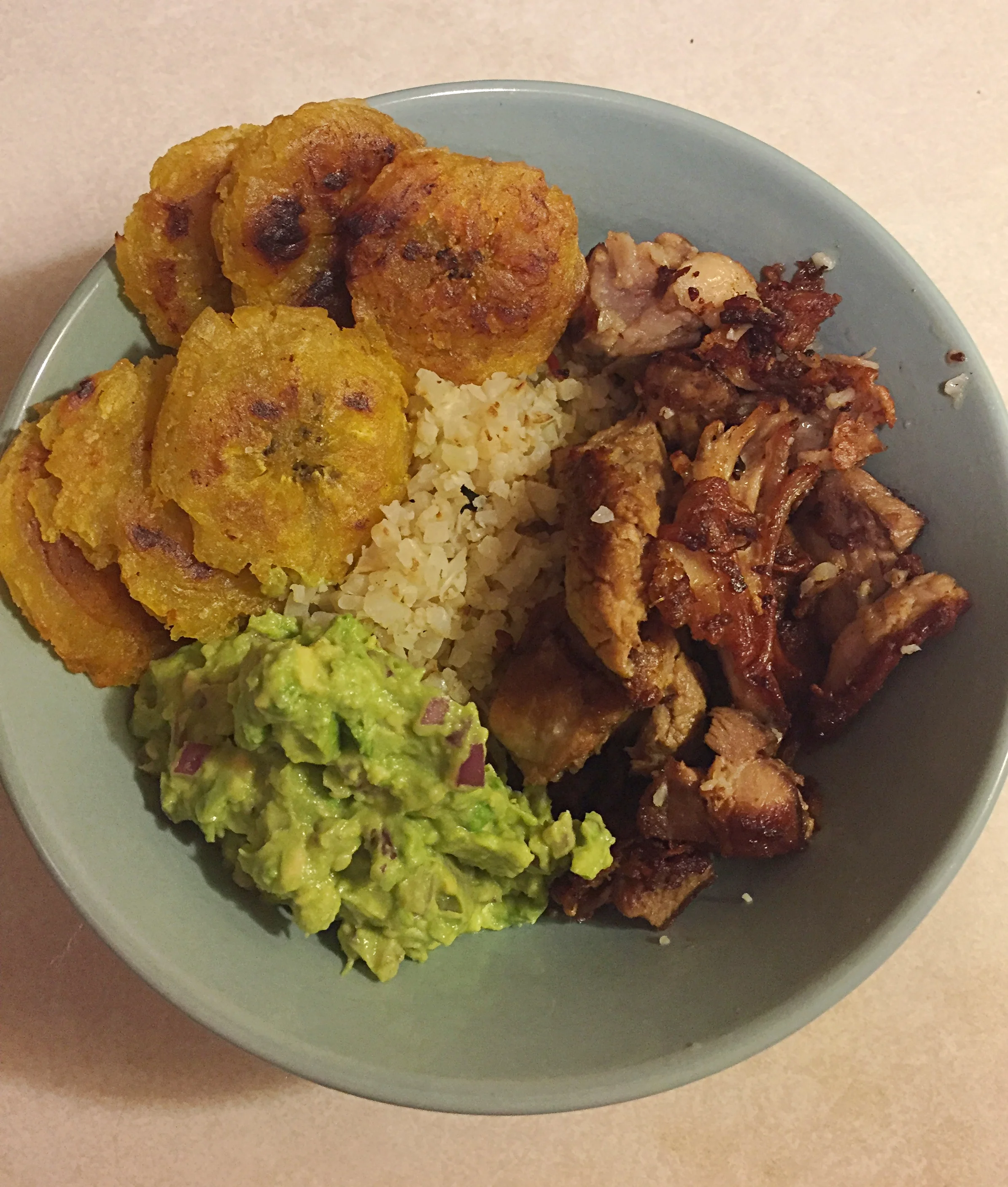 My latest and greatest: Leftover Nomnompaleo crispy Kalua Pig on a bed of fried cauliflower rice topped with homemade guacamole and homemade Tostones!
