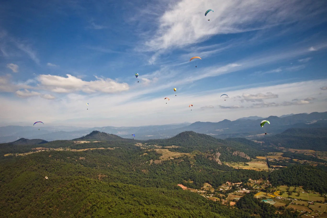 Looking "over the back" of launch toward (right to left) Las Peñitas cliffs and LZ fields and the peaks of Sacamacate, San Augustine and Escalaria forming the northeastern perimeter of the mesa. The lake and town of Valle de Bravo are out of view behind Escalaria.