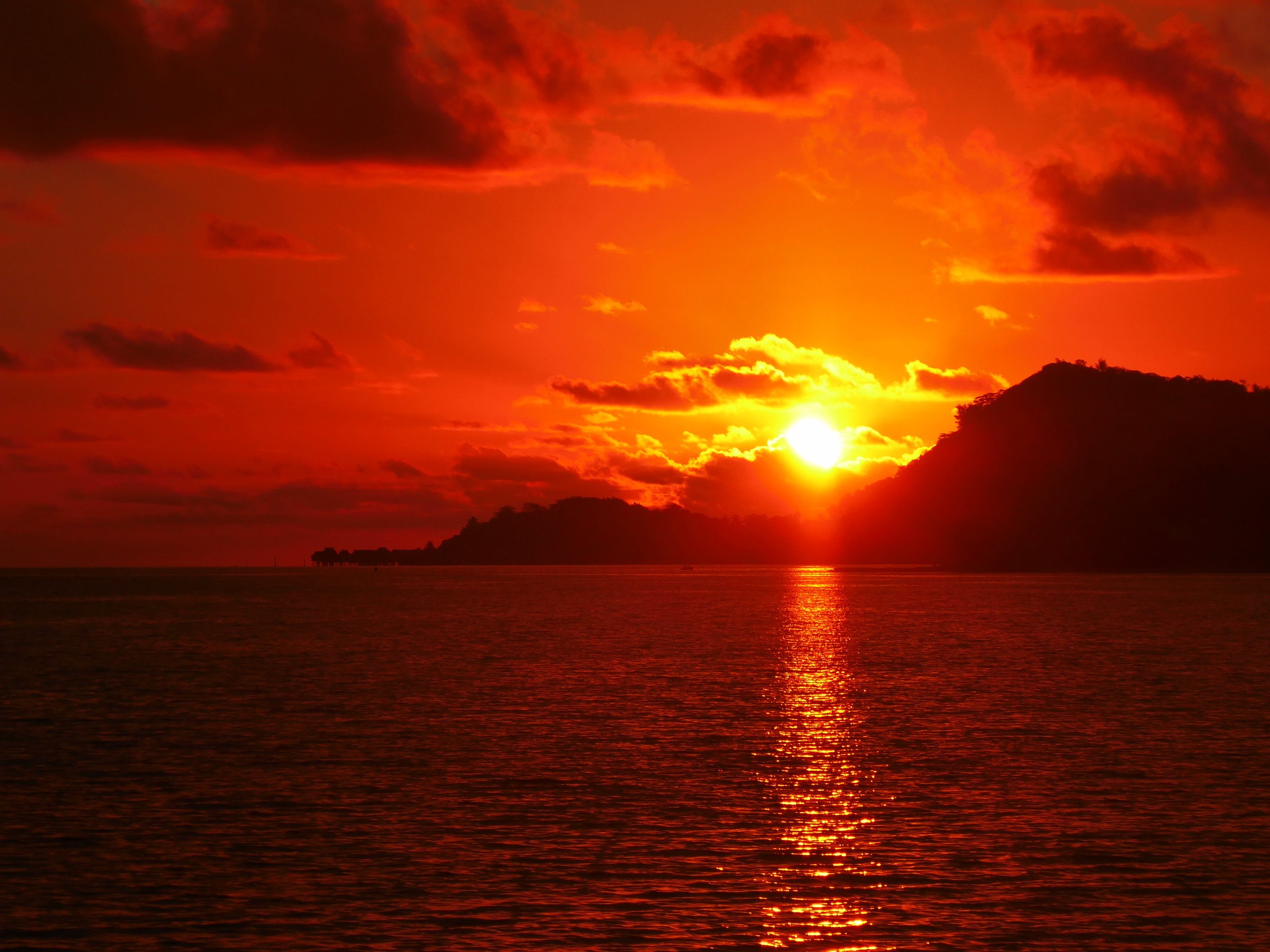 Watching the sun set from behind To'opua from Matira Beach