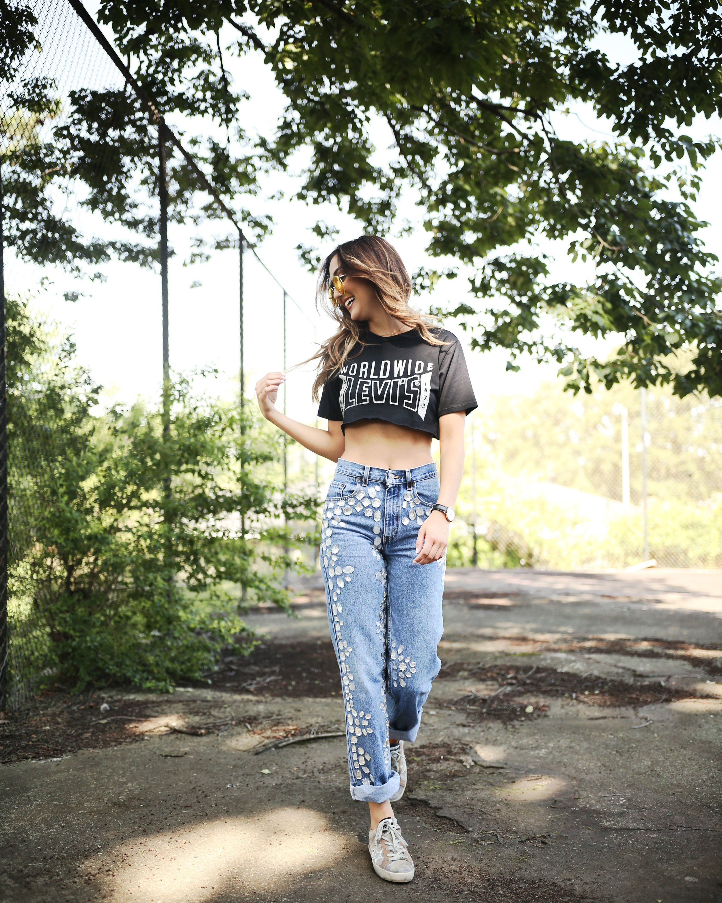 Gigi Hadid poses in a metallic crop top and loose-fitting jeans during a  photoshoot at