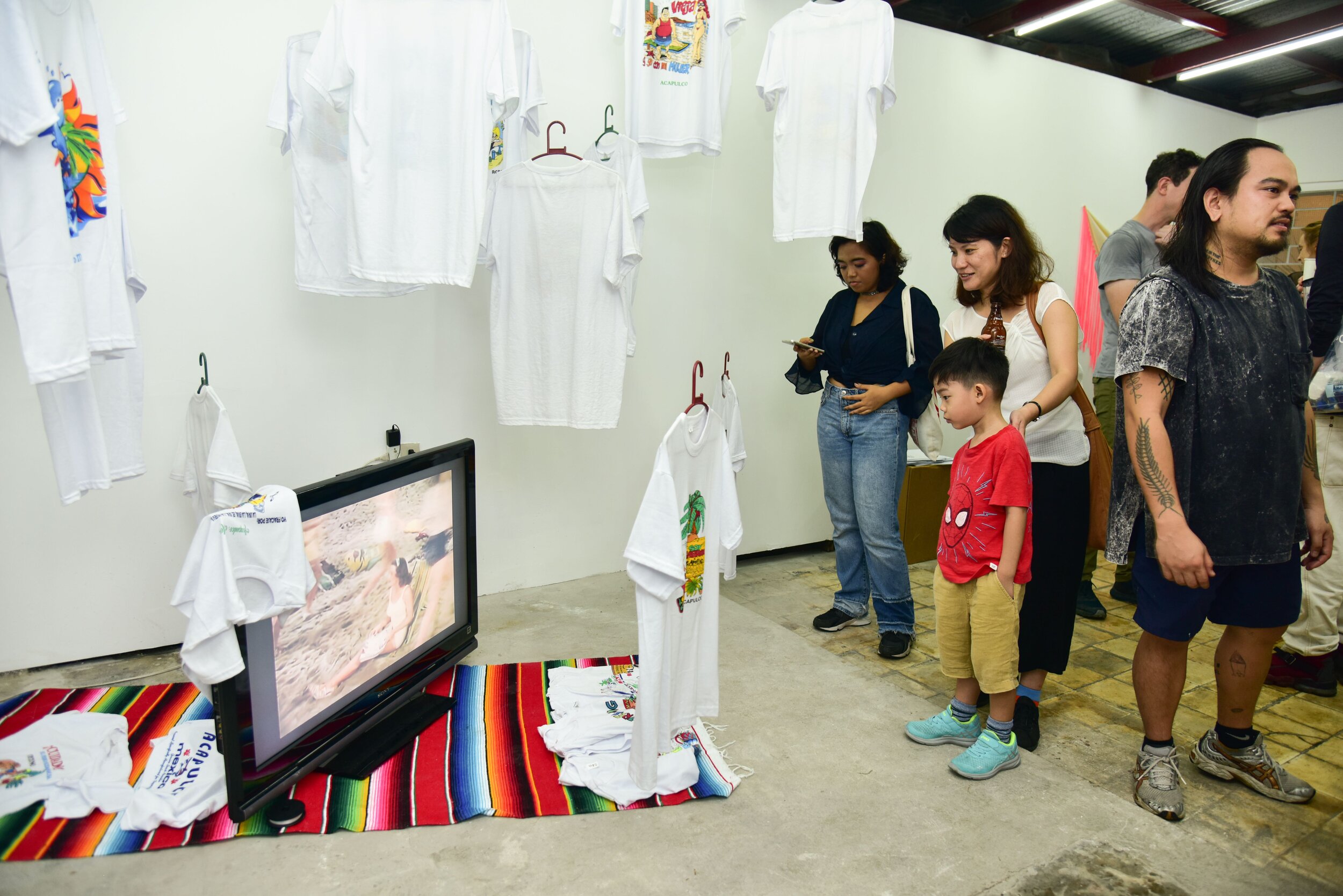 Cristóbal Gracia, "Nos Value Madres", 2019, mixed media, touristic t-shirts from Acapulco, sarape blanket; "Tres Amigos, the good, the bad and the stuped" video loop (3:35 mins) 